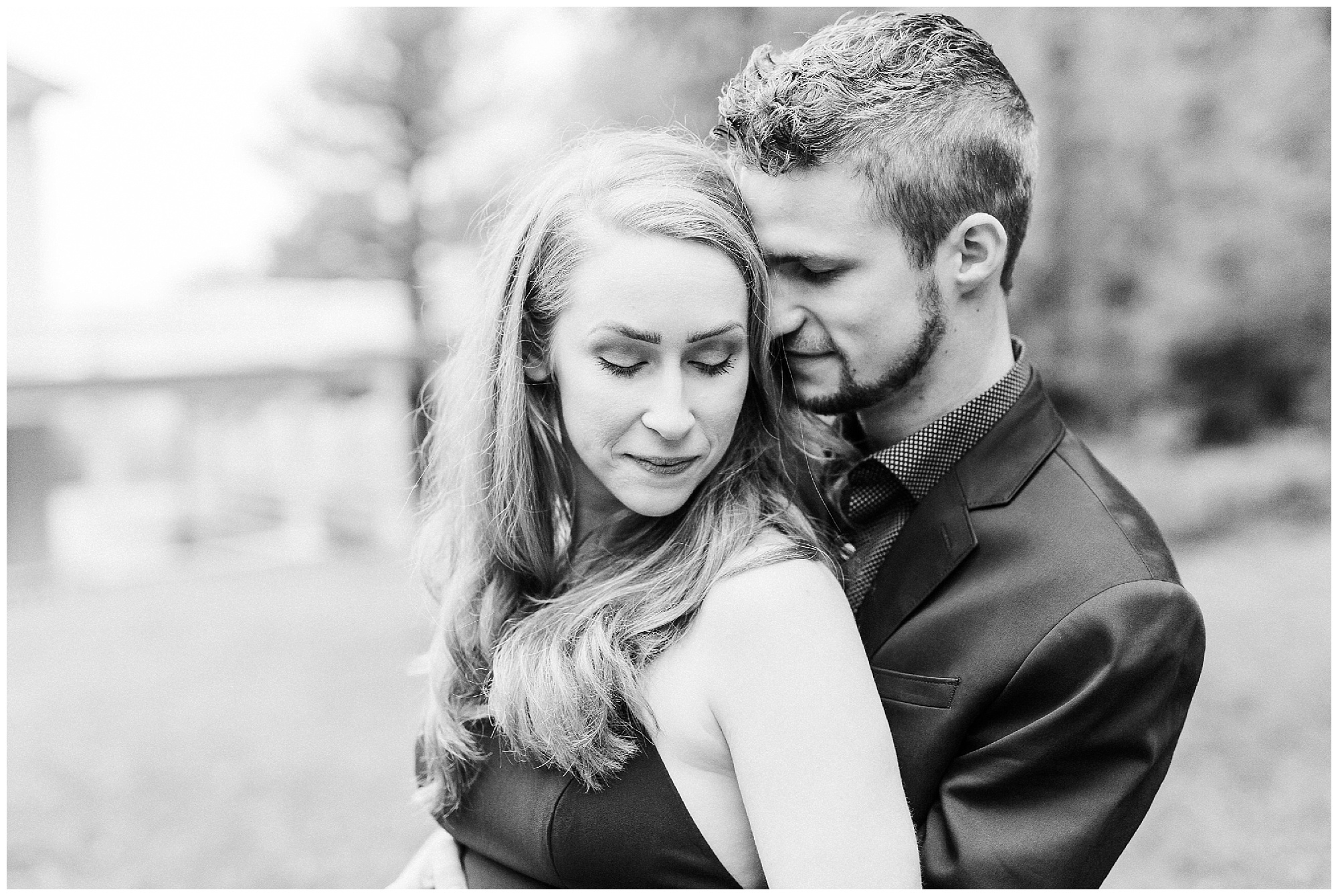 groom hugs bride nuzzling her hair during foggy mountain engagement session