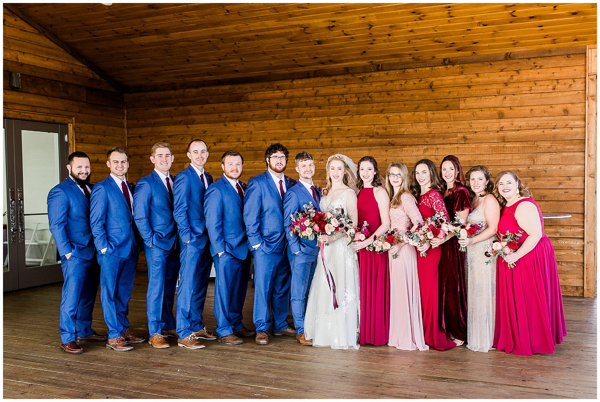 bride and groom pose with bridal party in navy and pinks outside Sky Retreat 