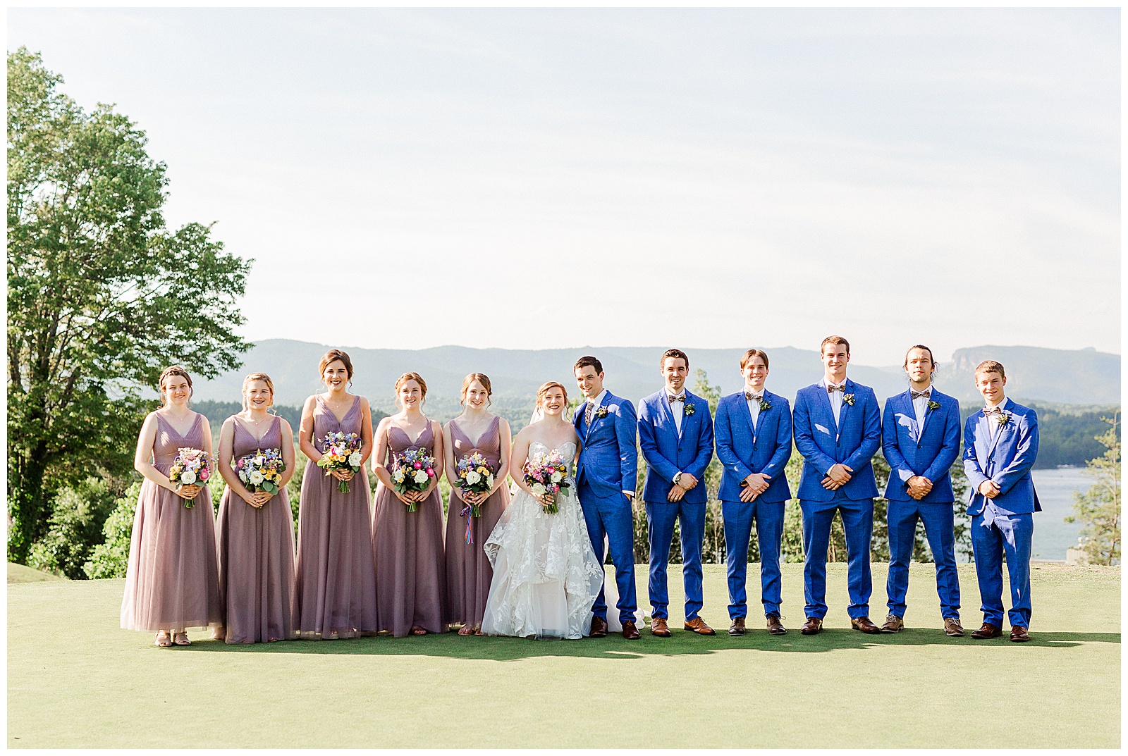 Lavender Purple Bridesmaid Dresses and Sailor Blue Groomsmen Suits color themed wedding group photo from Outdoorsy Summer Wedding at North Carolina Lakehouse in the Mountains | check out the full wedding at KevynDixonPhoto.com