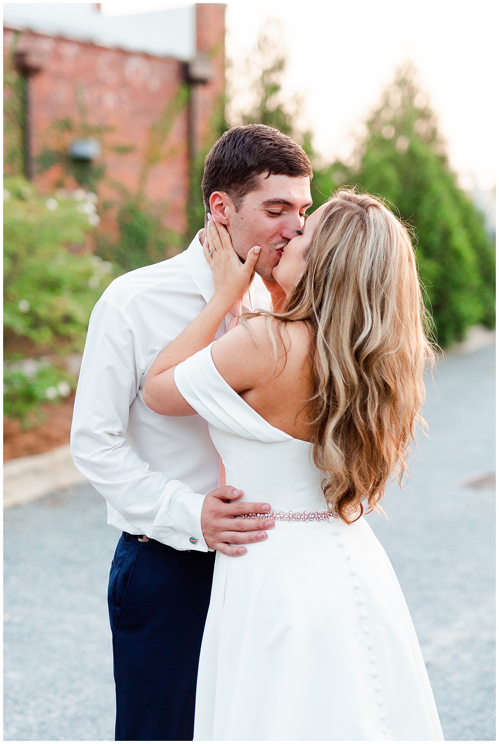 Stunning Modern Bride and Groom with off shoulder wedding dress and blue suit in outdoor portraits in empty parking lot from Summer Wedding in Charlotte, NC | Check out the full wedding at KevynDixonPhoto.com