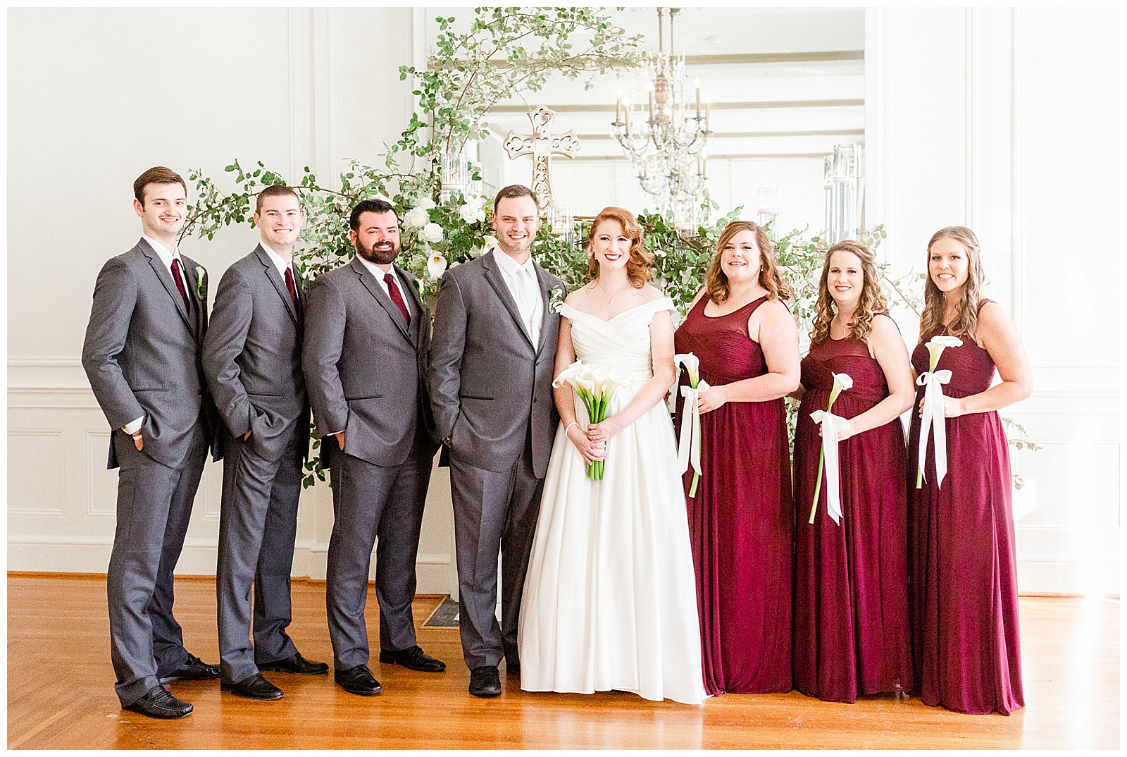 Gorgeous Bridal Party Portraits with red-themed bridesmaid dresses at elegant indoor floral venue in 1940s Modern Vintage Wedding in Charlotte, NC | check out the full wedding at KevynDixonPhoto.com