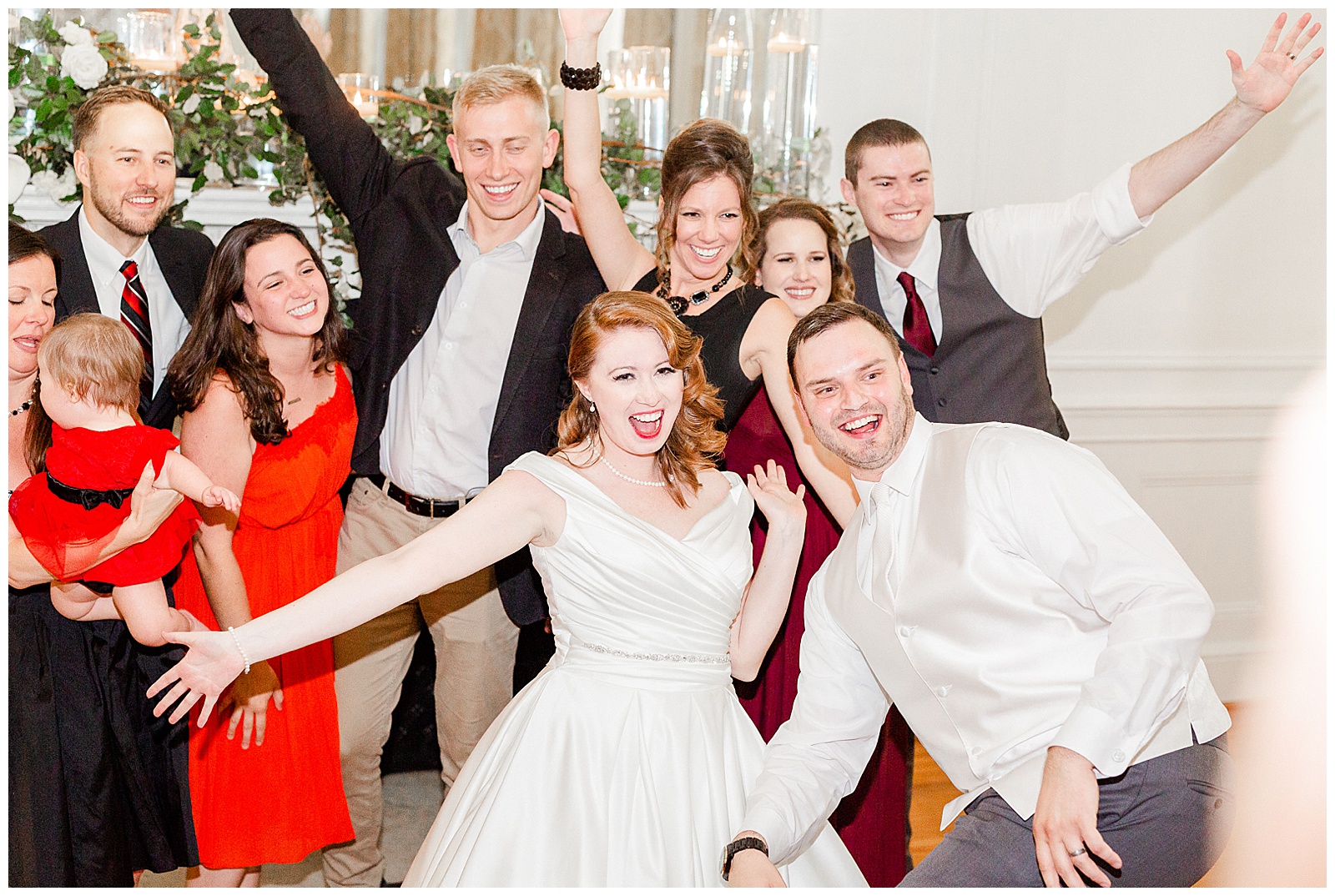 Goofy Group Photo with gorgeous red-haired bride at elegant indoor floral venue in 1940s Modern Vintage Wedding in Charlotte, NC | check out the full wedding at KevynDixonPhoto.com