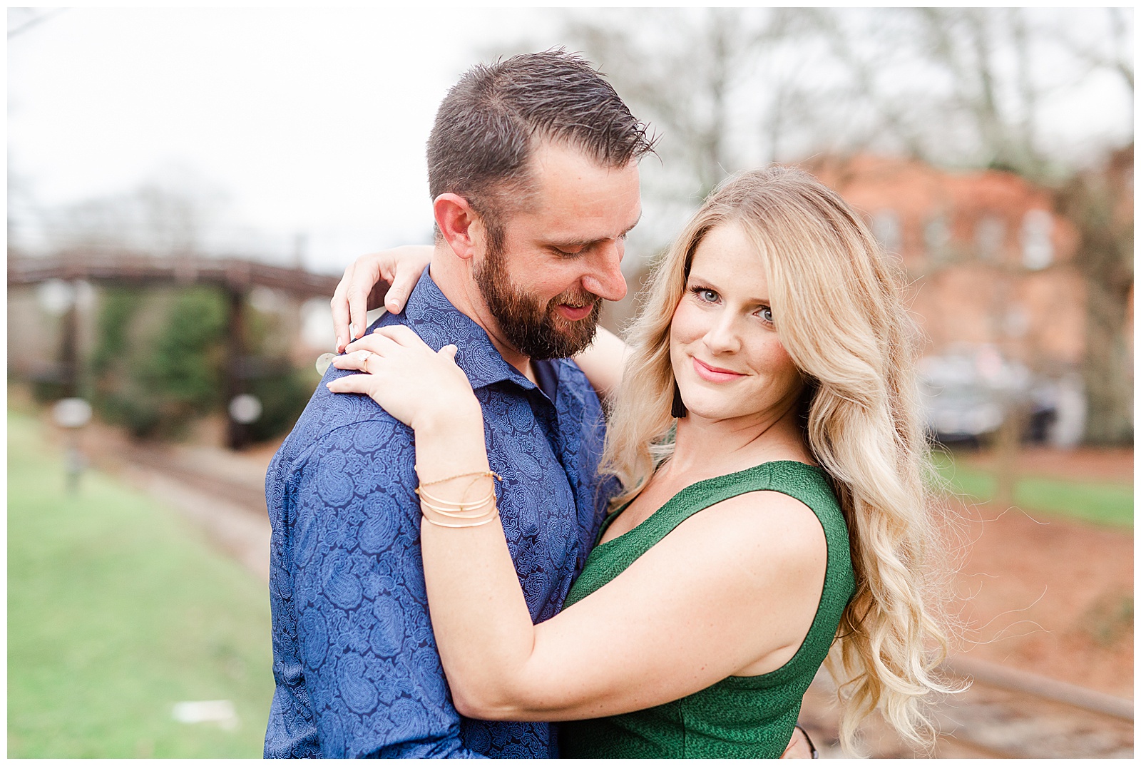Adorable couple near old train tracks in downtown Waxhaw, NC Engagement Session with Green Dress Outfit Ideas