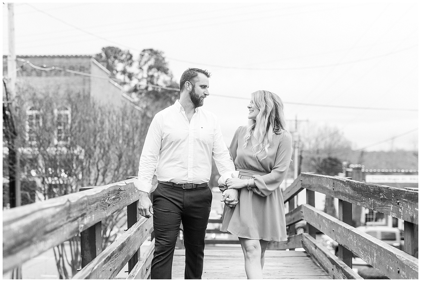 Adorable couple walking across wooden bridge in downtown Waxhaw, NC Engagement Session with Bright Hot Pink Dress Outfit Ideas