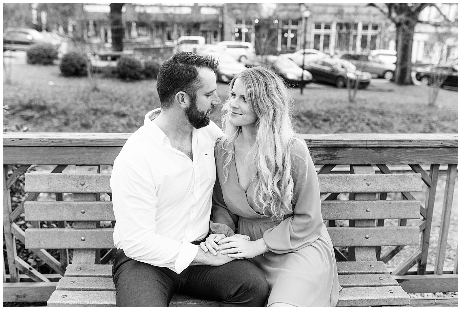 Adorable couple sitting on wooden bench in downtown Waxhaw, NC Engagement Session with Bright Hot Pink Dress Outfit Ideas