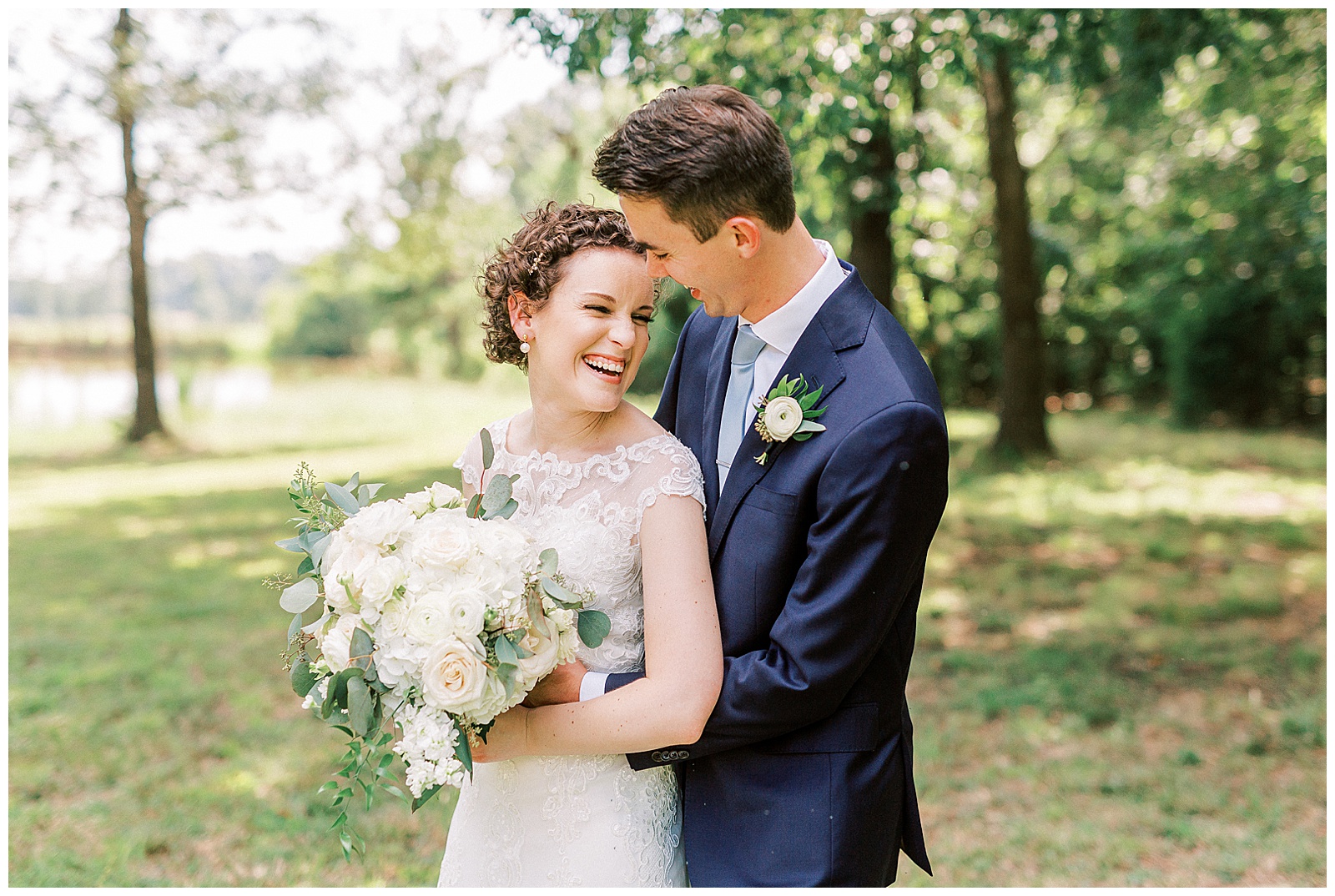 outside bride groom wedding day portraits curly short haired bride with lace wedding dress and navy blue suit groom