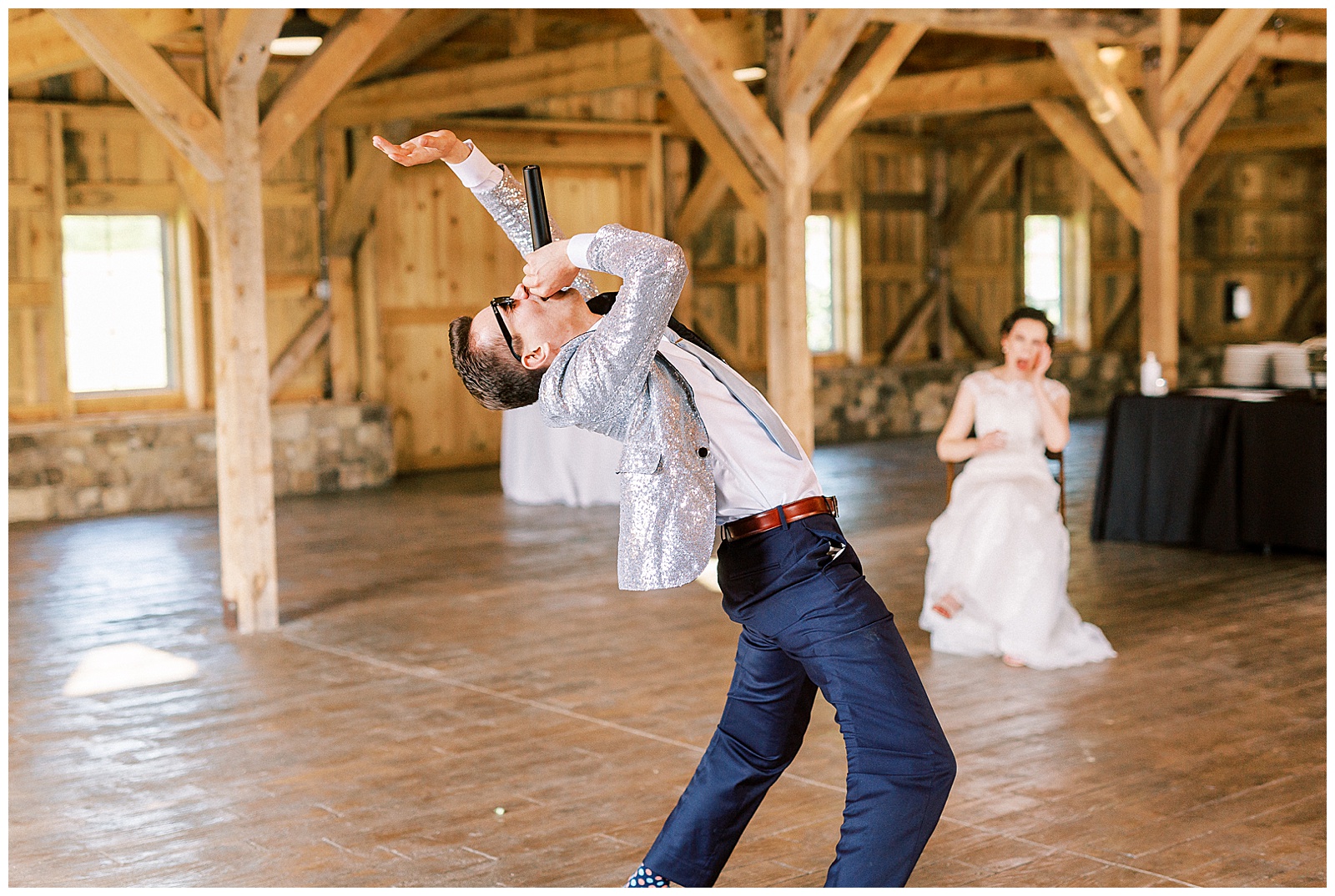 groom performs hilarious surprise song for bride in wooden open barn wedding venue