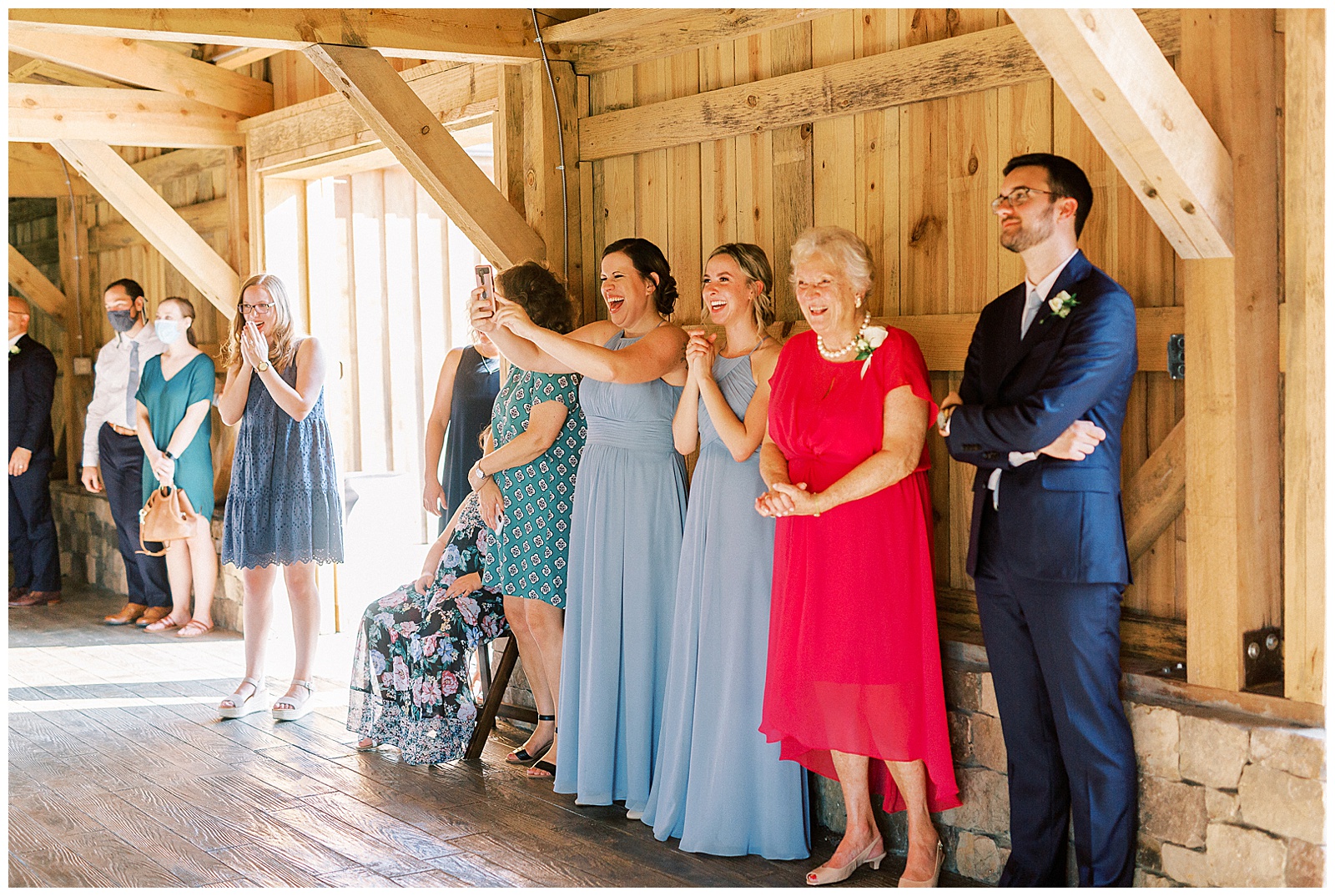 guests clap for groom performs hilarious surprise song for bride in wooden open barn wedding venue