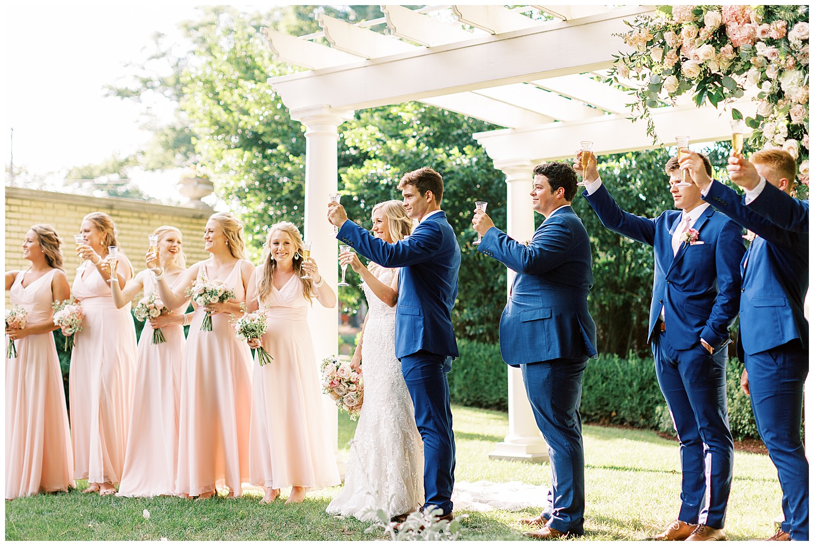 summer wedding toast outdoors at separk mansion with navy royal blue and soft pink bridal party