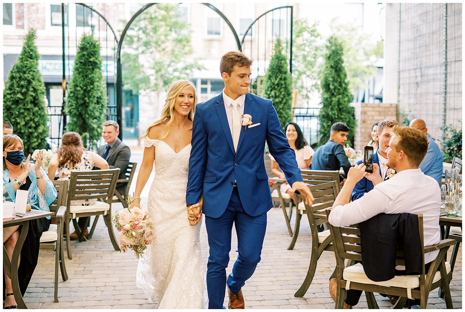 bride and groom enter esquire hotel outdoor patio wedding reception