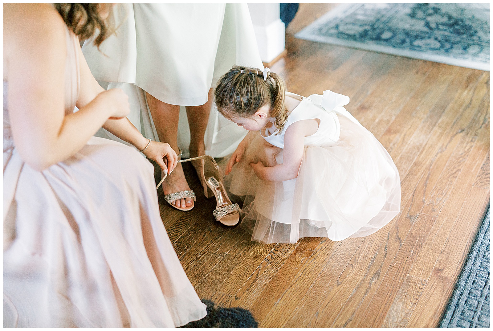 bride getting ready in lace wedding dress with flower girl in pink dress