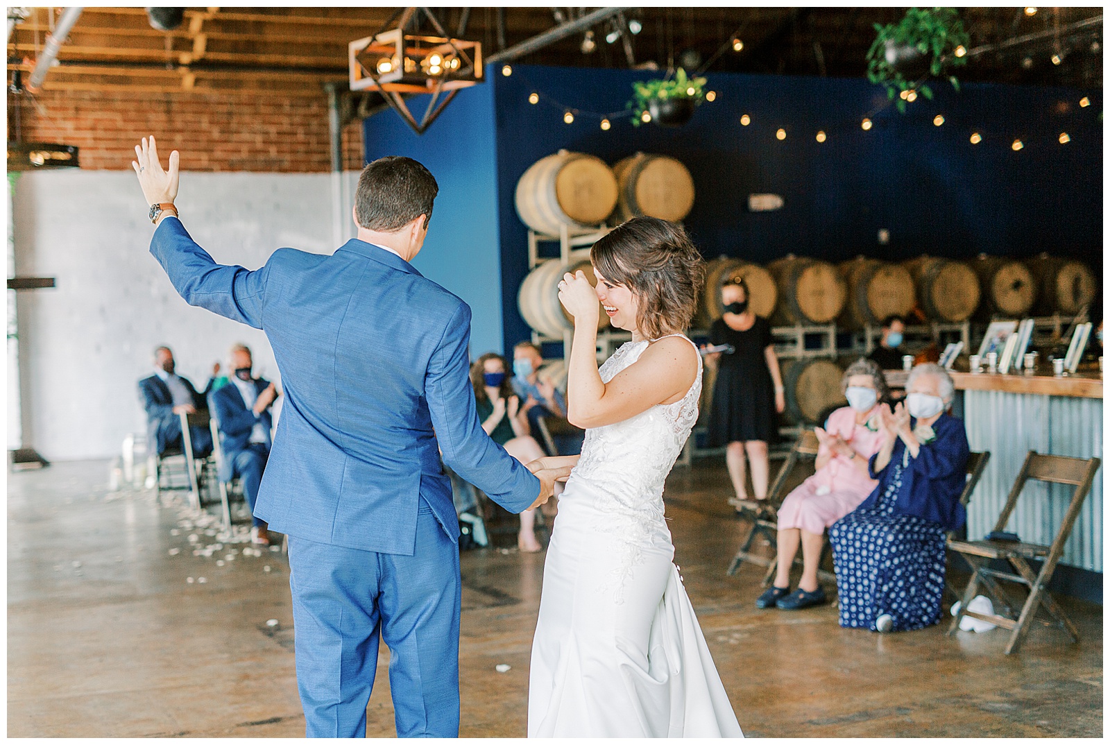bride and groom first dance in stunning modern catering space with fairy lights