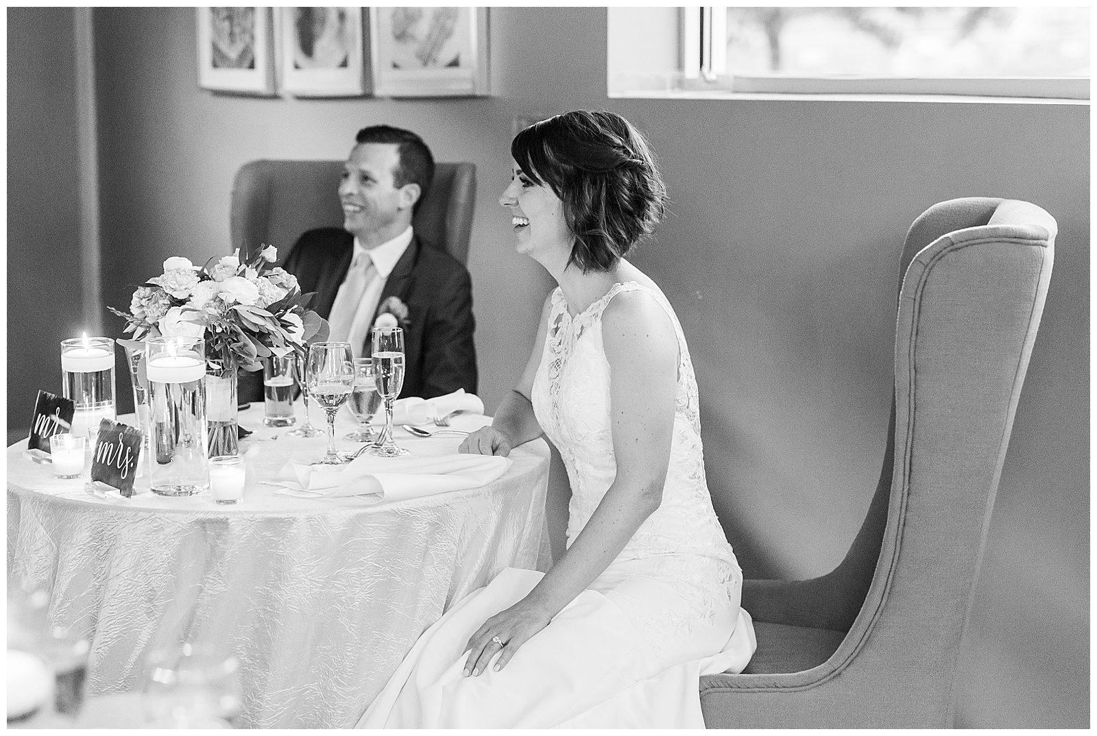 bride and groom at table in stunning modern catering space with fairy lights