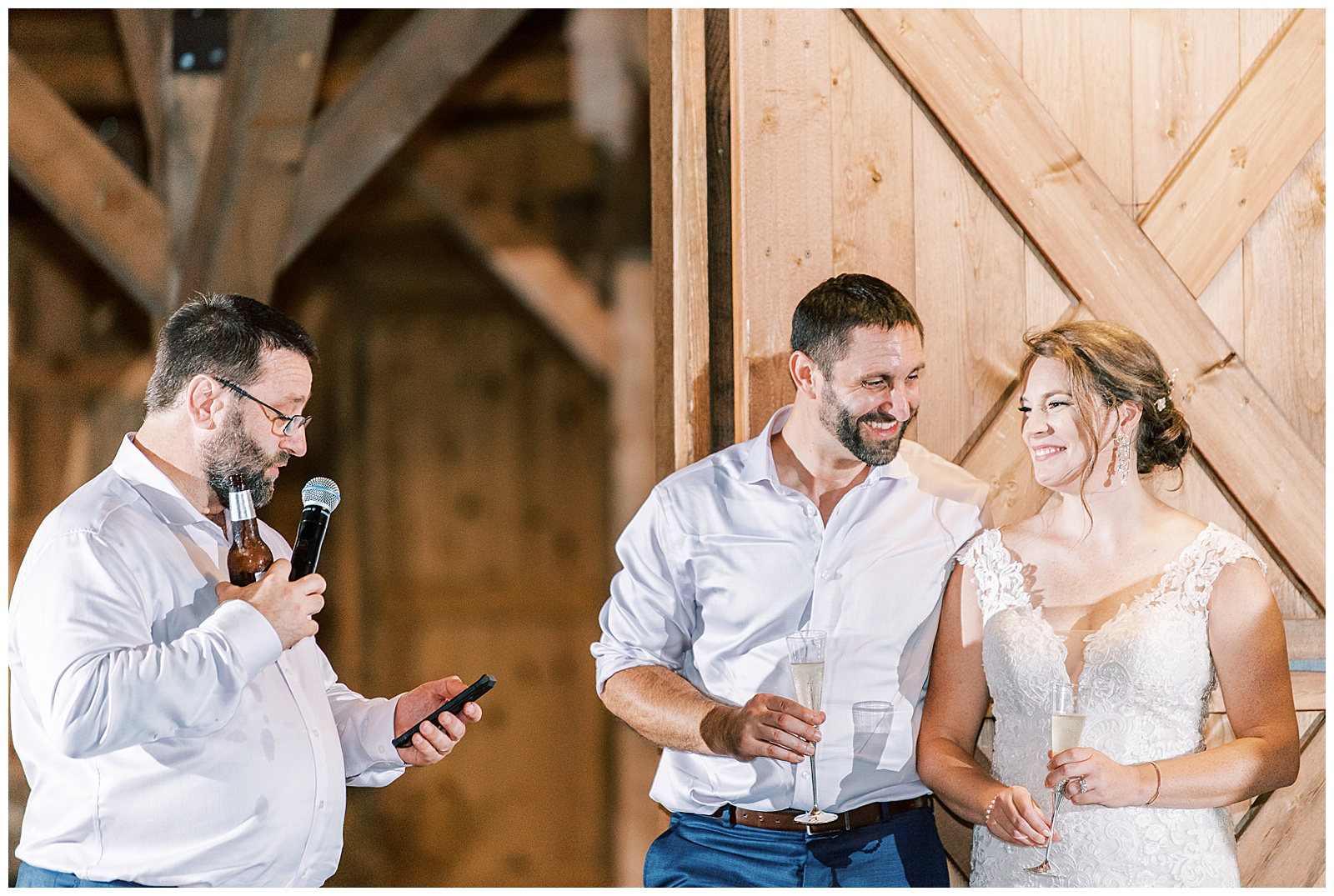 bride and groom at indoor summer wedding reception in wooden barn