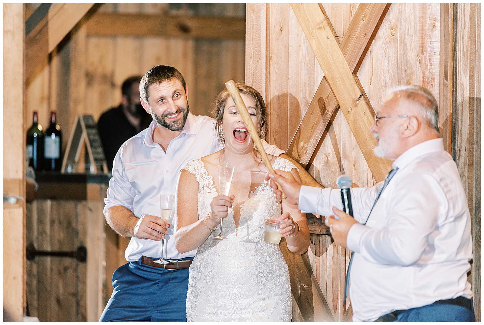 bride and groom at indoor summer wedding reception in wooden barn