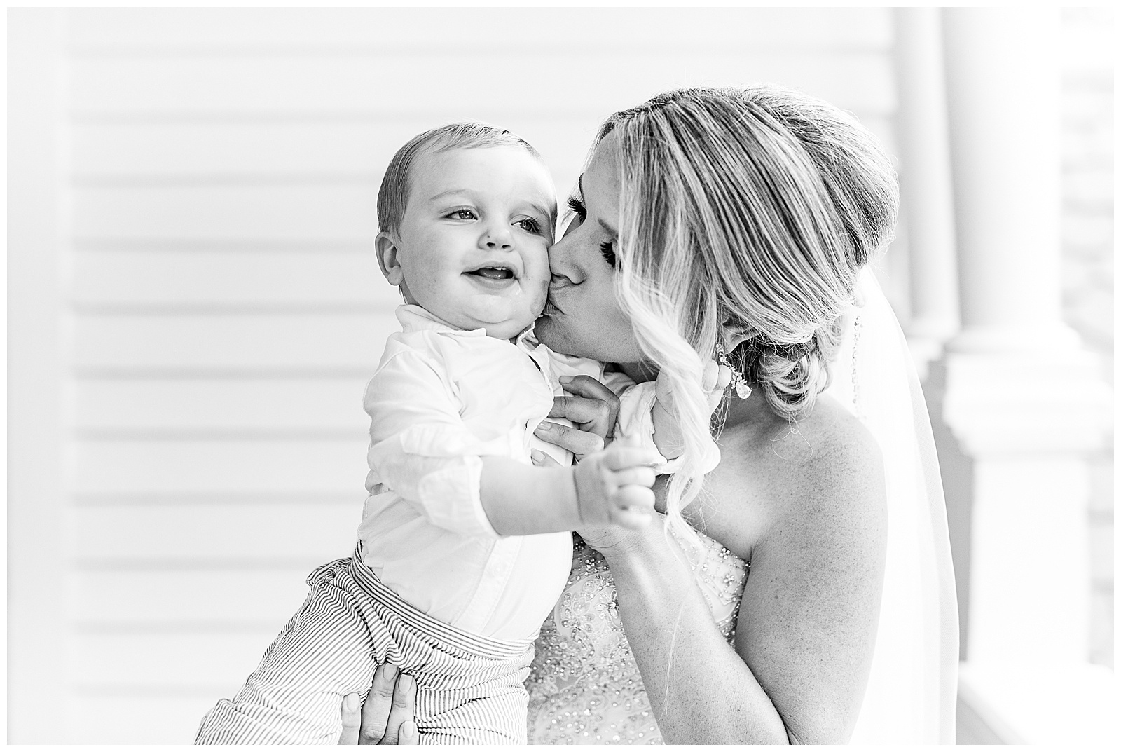 blonde haired bride kisses sweet baby son in gorgeous light and airy outdoor bridal portraits
