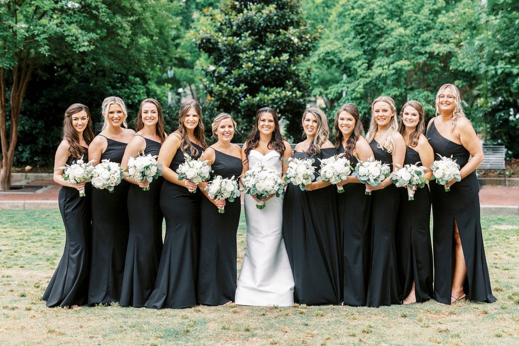 bride and bridesmaids pose in Uptown Charlotte park