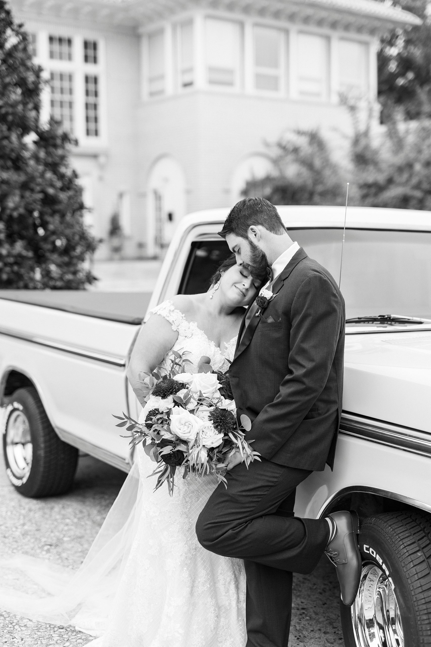 bride and groom hug against resorted blue Ford truck