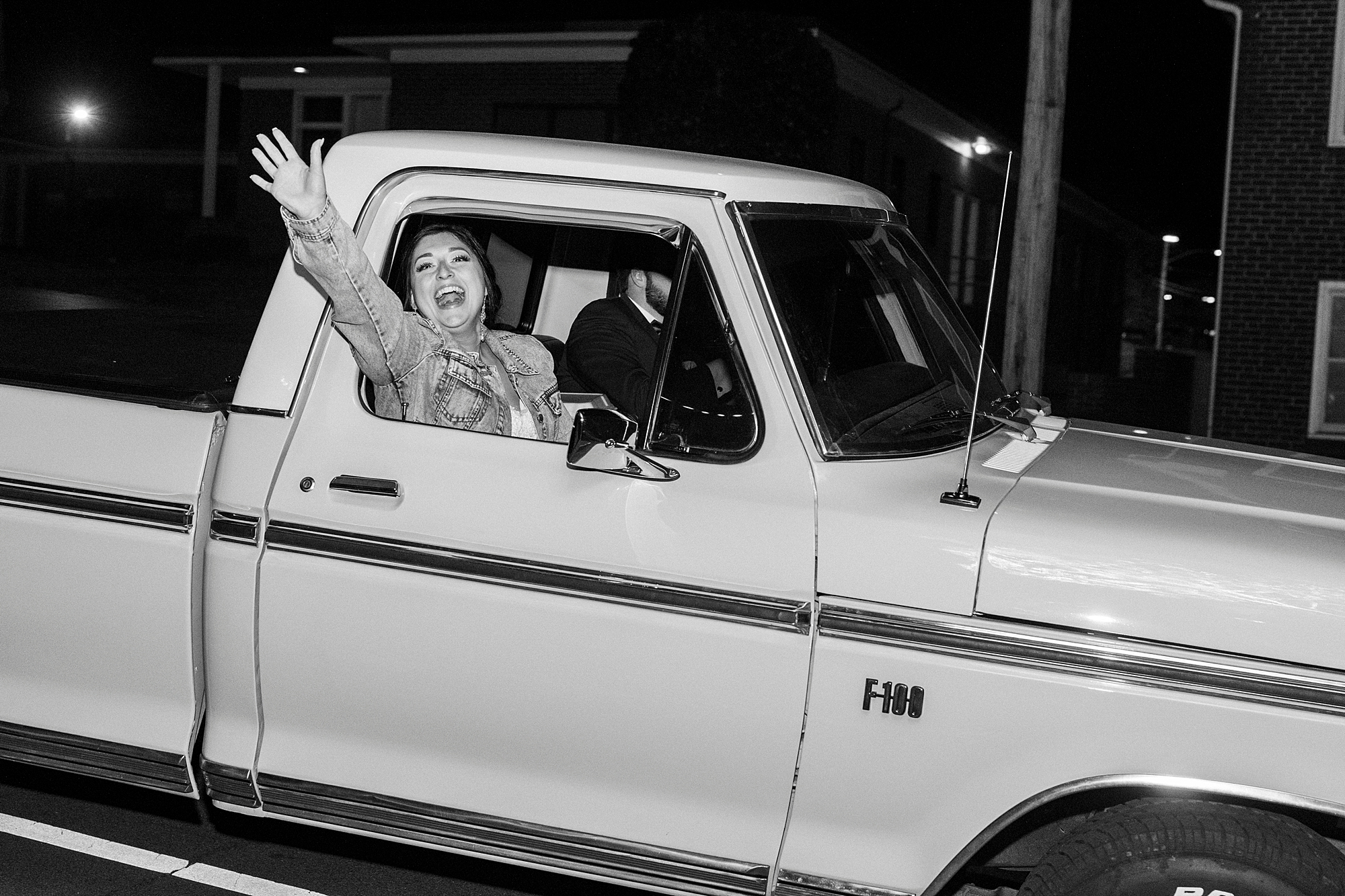 bride and groom wave in Ford Truck leaving wedding reception 