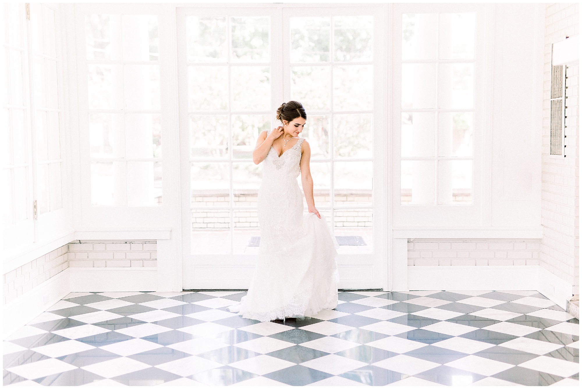 bride in white dress in black and white tiled sunroom