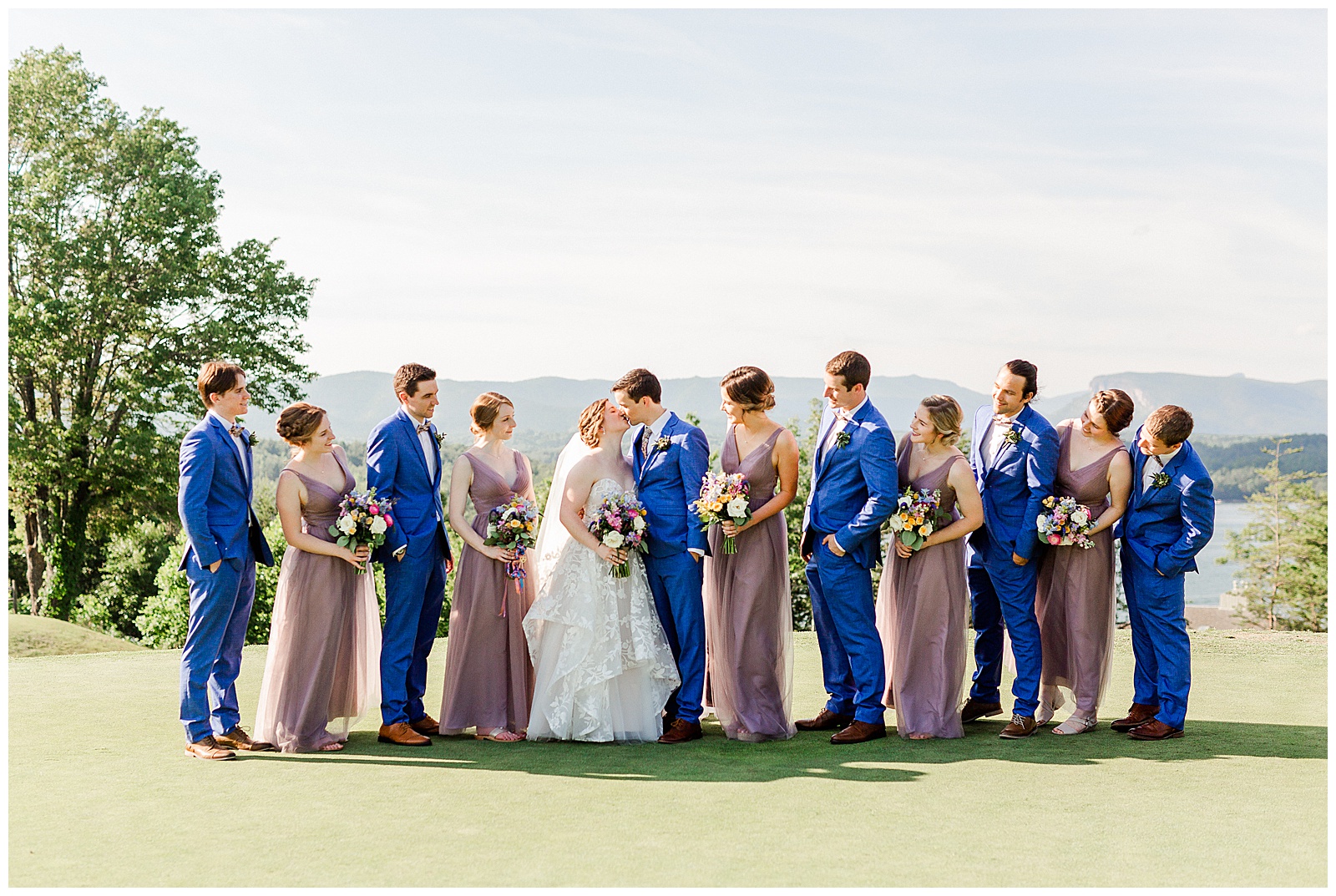 Lavender Purple Bridesmaid Dresses and Sailor Blue Groomsmen Suits color themed wedding group photo from Outdoorsy Summer Wedding at North Carolina Lakehouse in the Mountains | check out the full wedding at KevynDixonPhoto.com