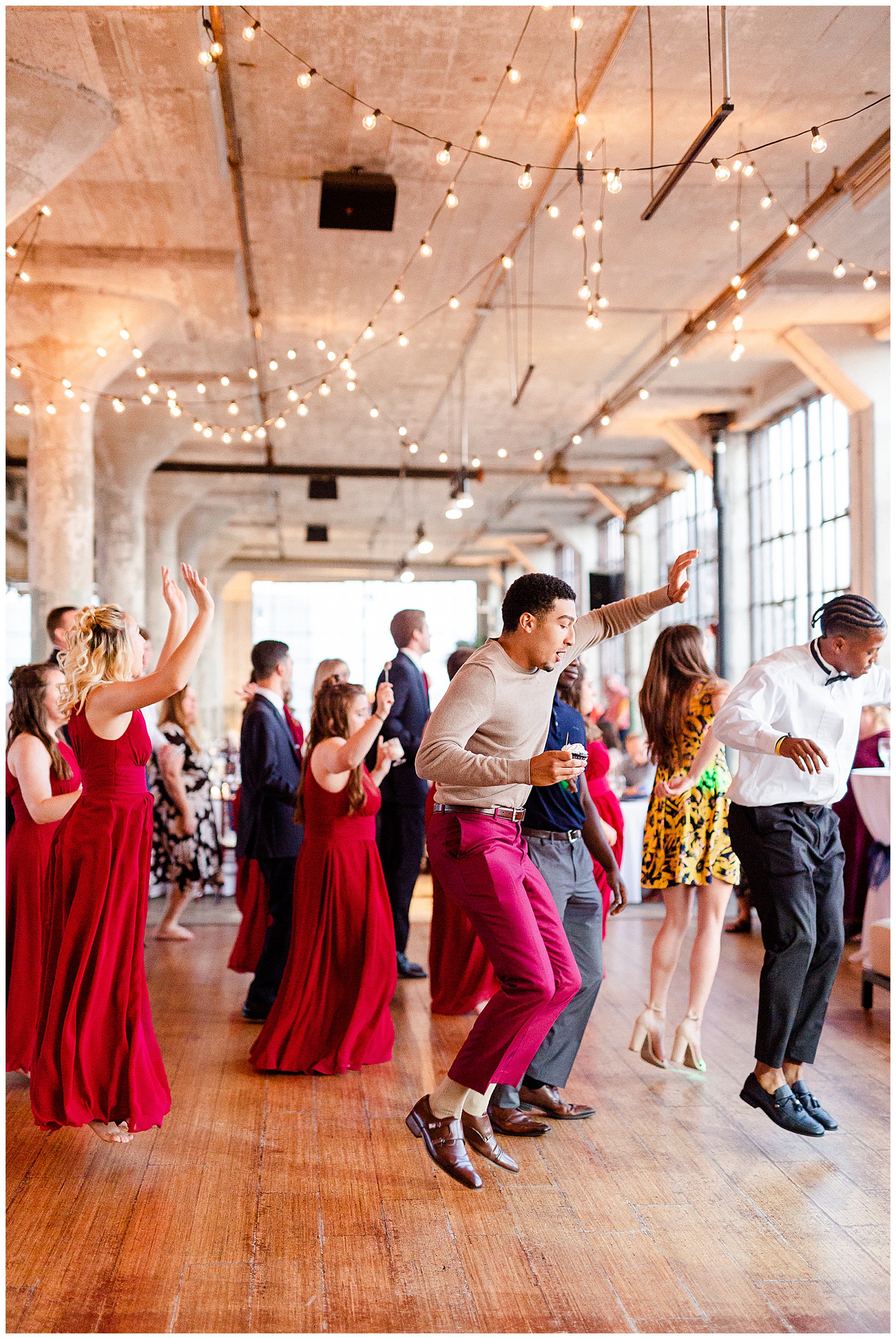 Join the dance party at Rustic Airy Indoor Wedding Venue with fairy lights - Red-Themed Bridesmaid Dress Ideas from Elegant Modern Summer Wedding in Charlotte, NC | check out the full wedding at KevynDixonPhoto.com