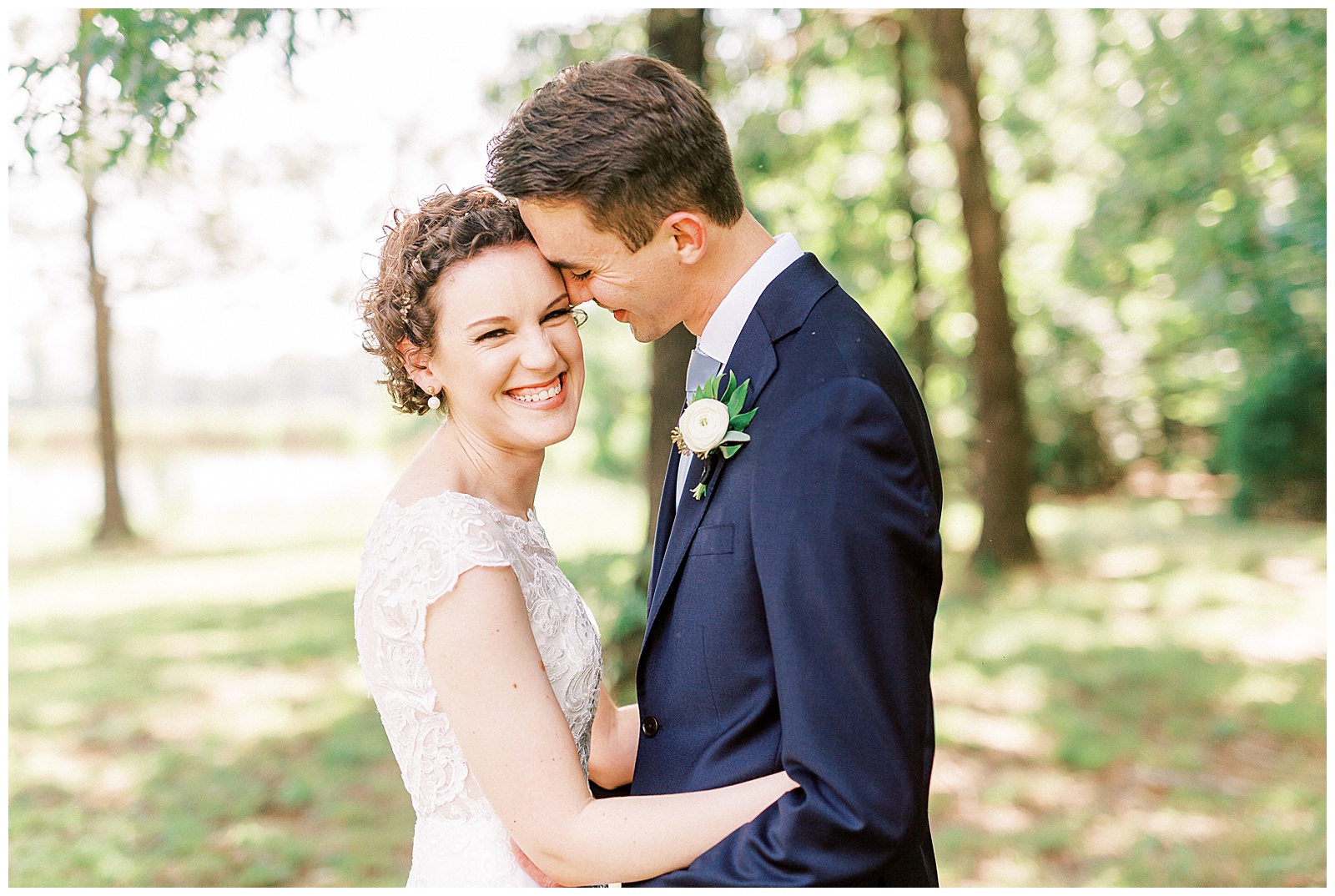 outside bride groom wedding day portraits curly short haired bride with lace wedding dress and navy blue suit groom