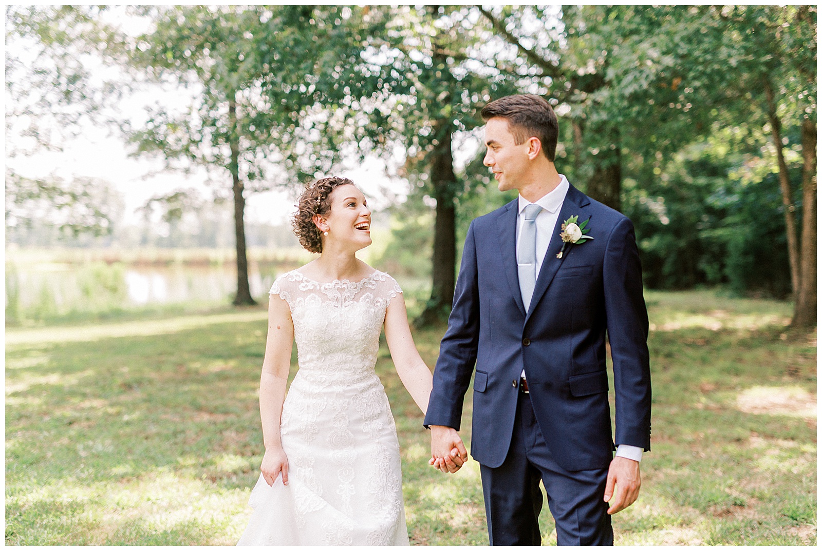 outside bride groom wedding day portraits curly short haired bride with lace wedding dress and navy blue suit groom