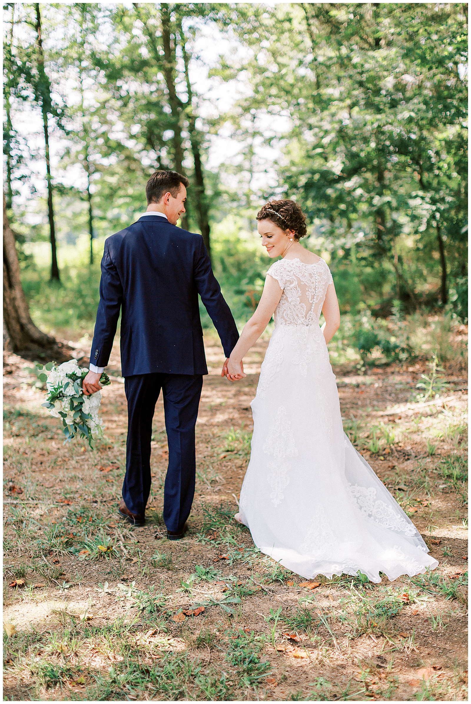 outside bride groom wedding day portraits curly short haired bride with lace wedding dress and navy blue suit groom