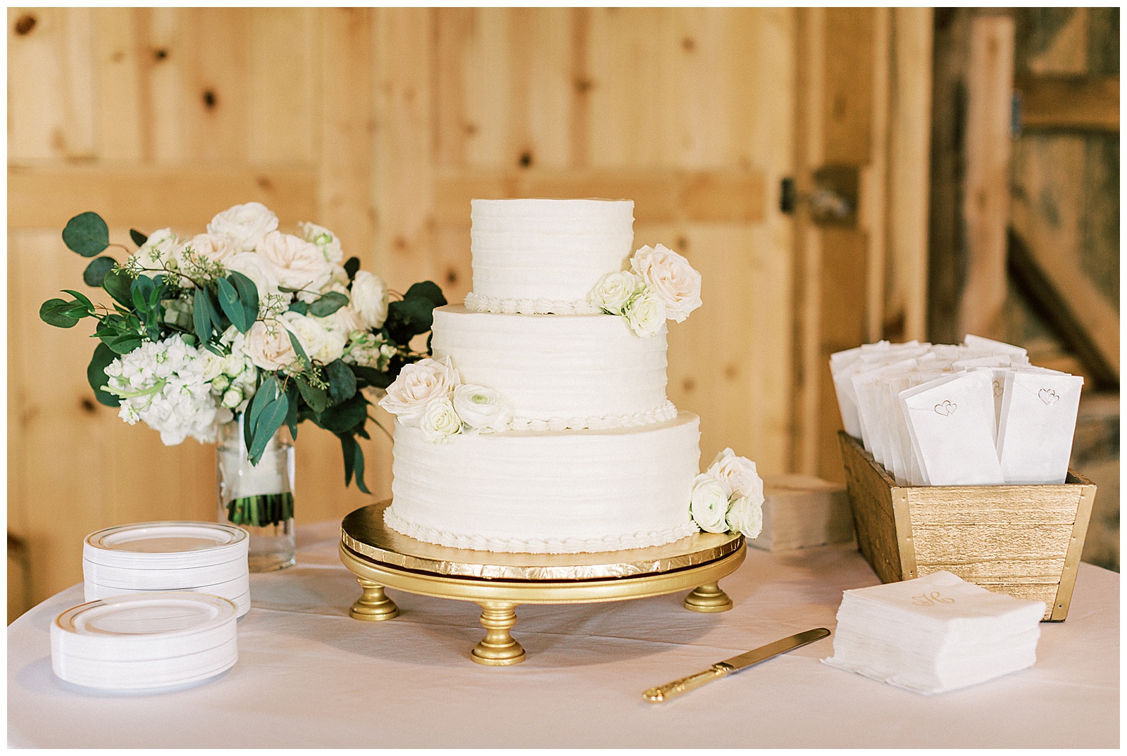 three tiered intricate wedding cake with flowers and bouquet