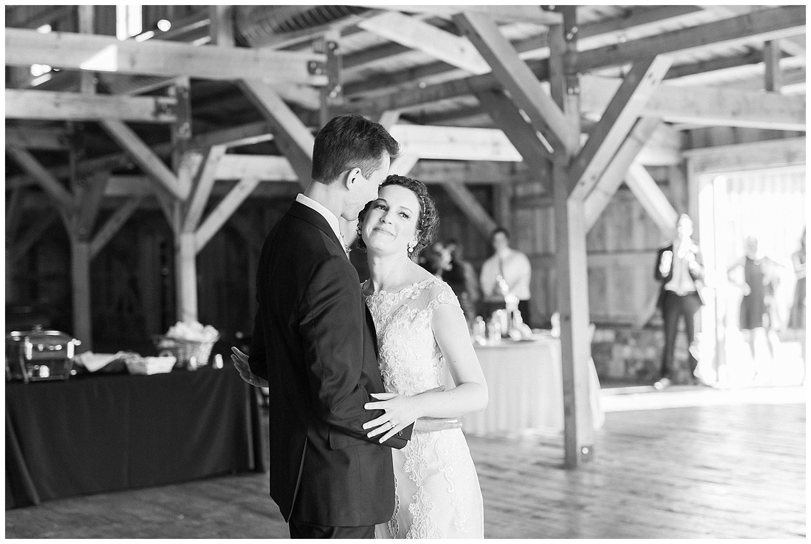 bride and groom first dance in huge open wooden barn venue