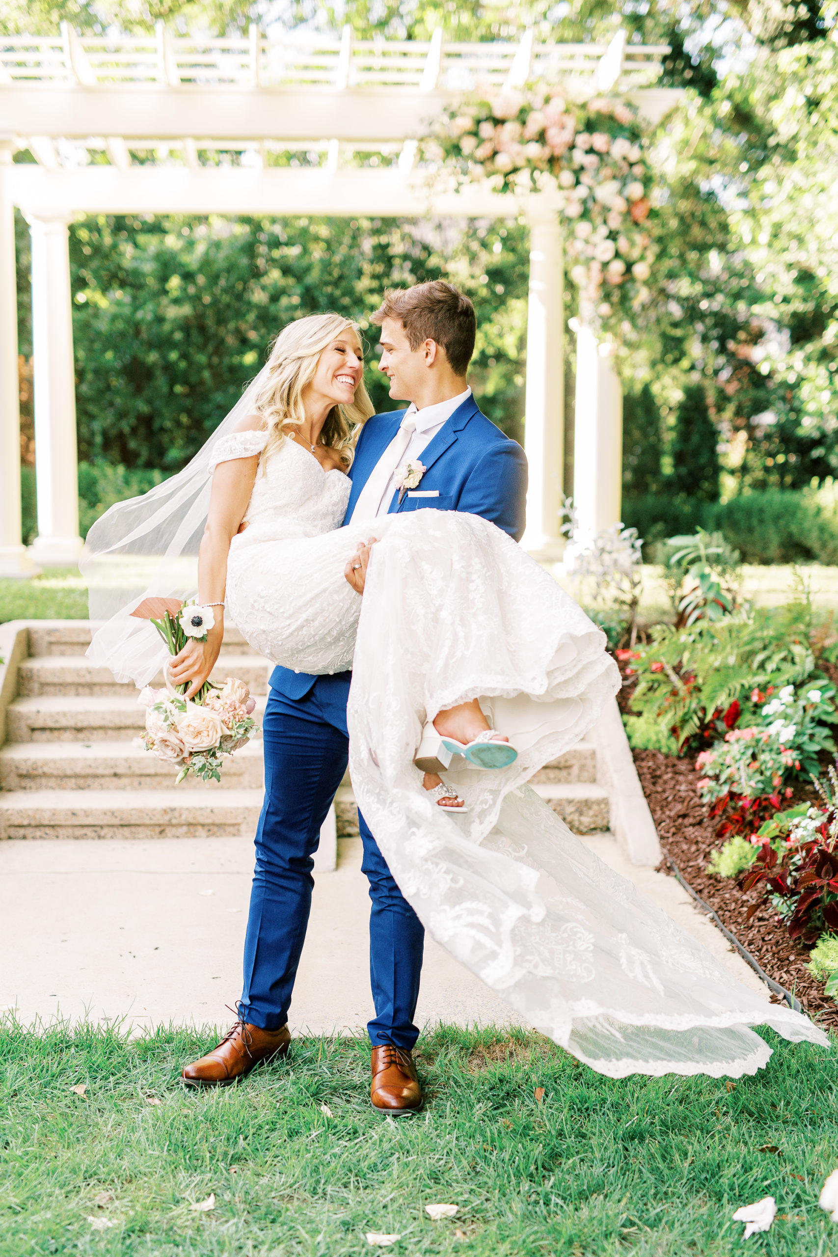 groom picking up bride in lace dress