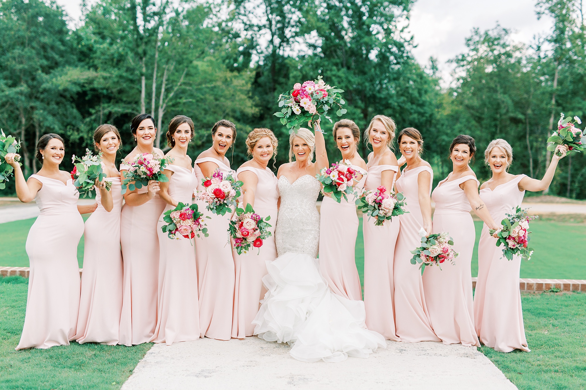 bridesmaids cheer for bride during wedding photos