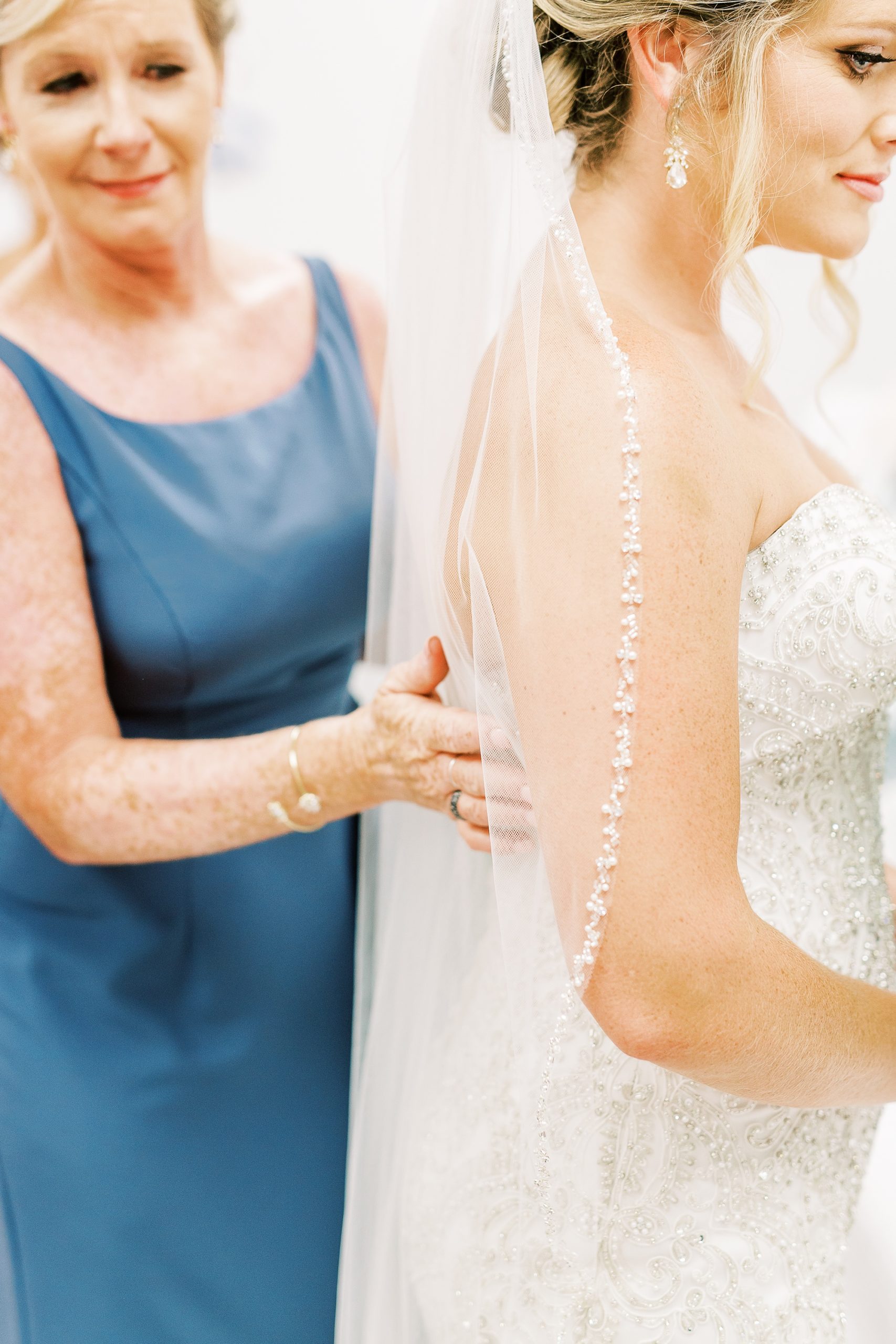 other of the bride adjusts veil for bride