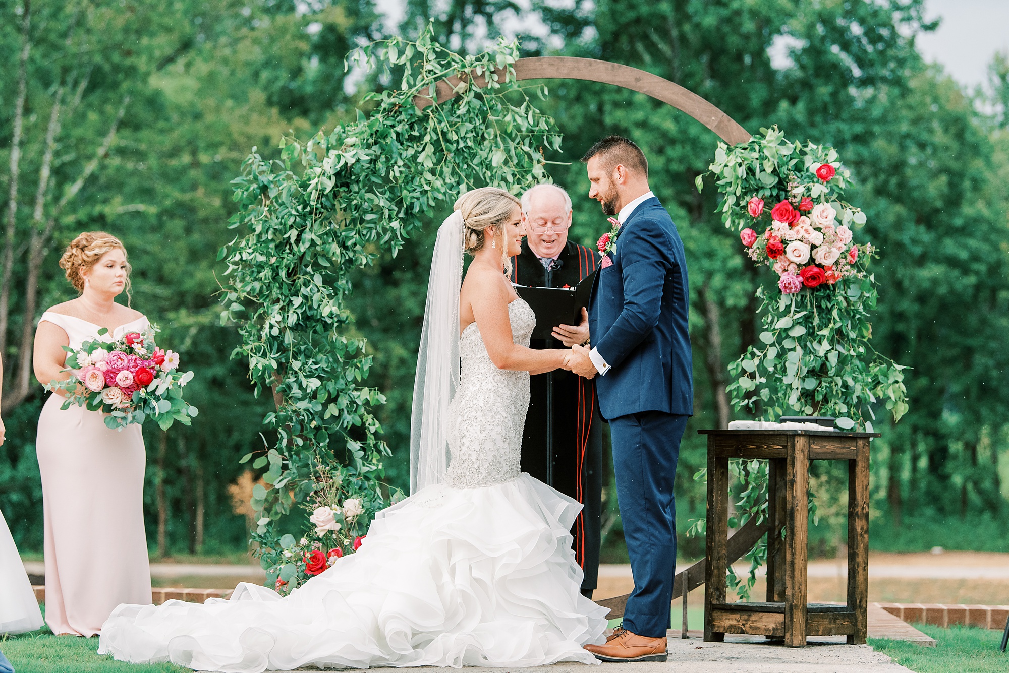 bride and groom exchange wedding vows in front of circular arch