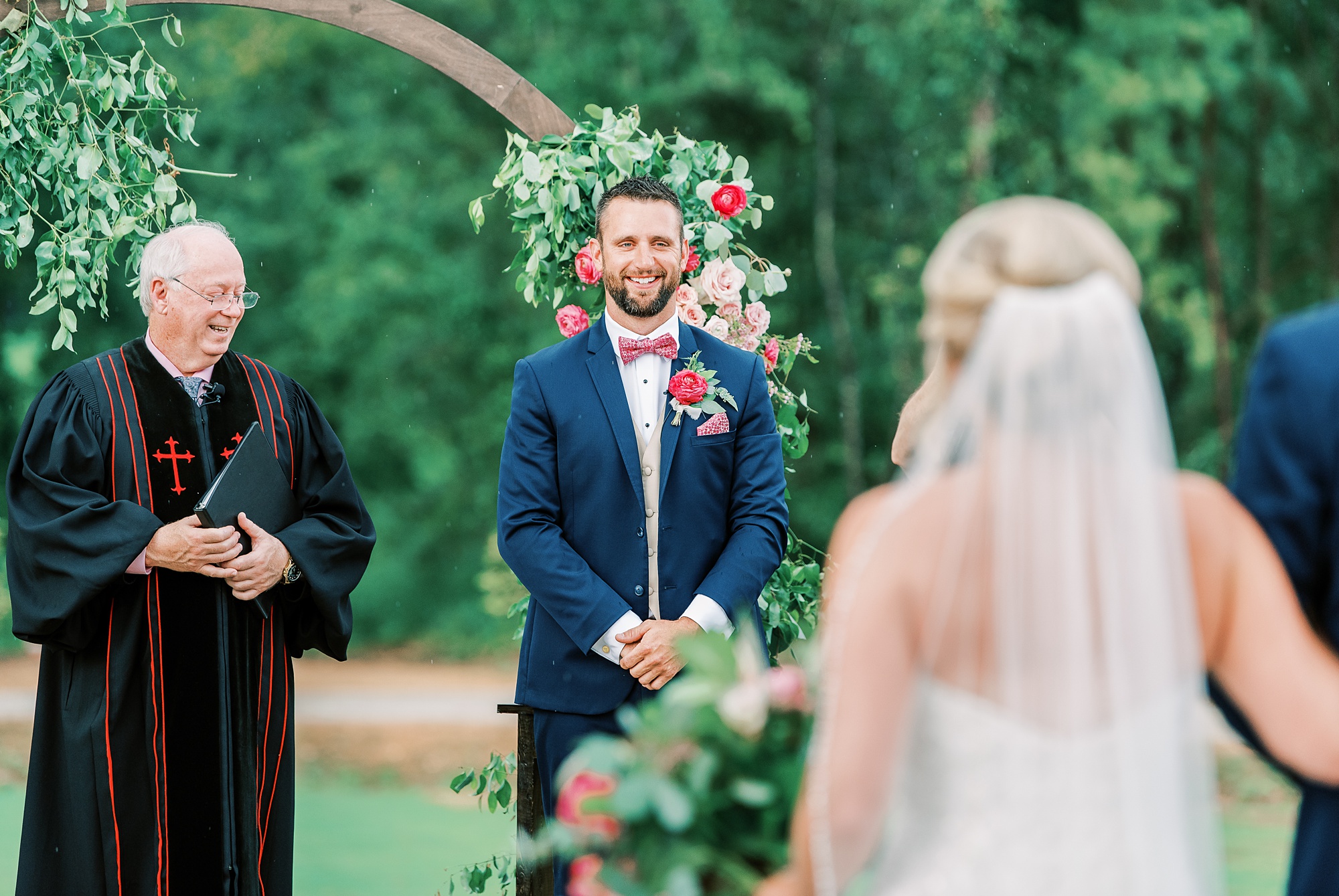 groom watches bride walk down the aisle