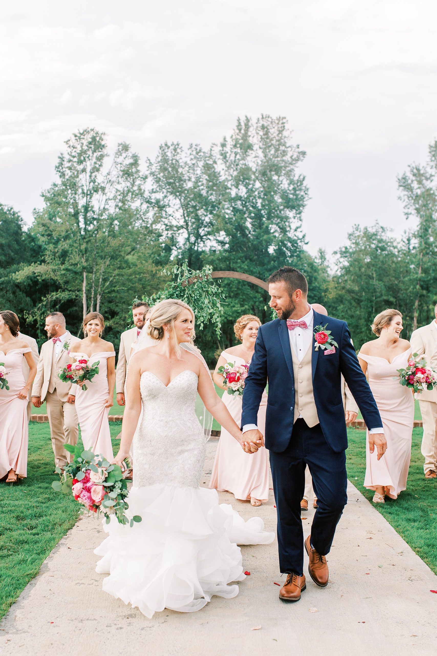 newlyweds walk with bridal party during Belle's Venue wedding