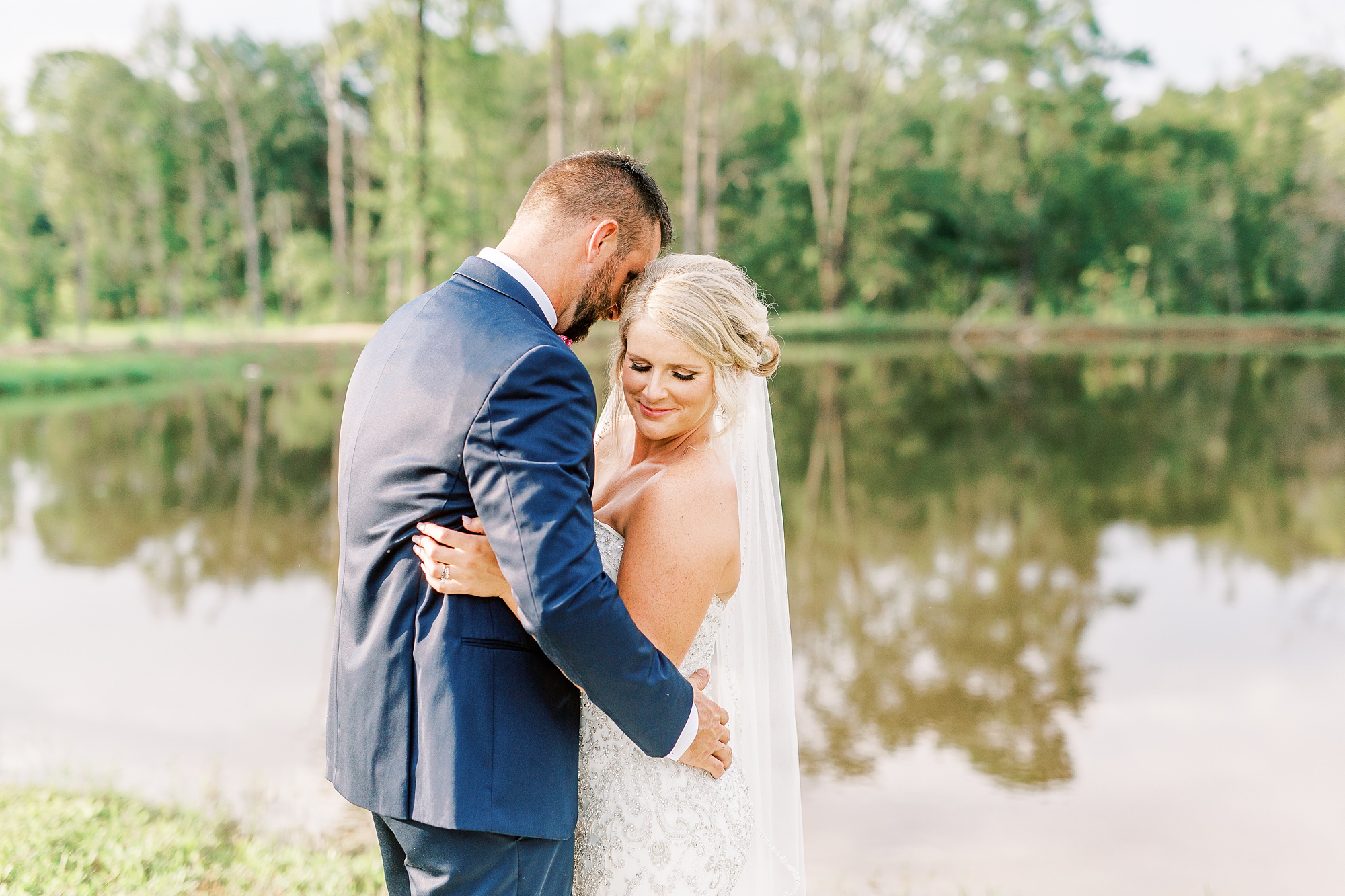 bride and groom hug by pond at Belle's Venue