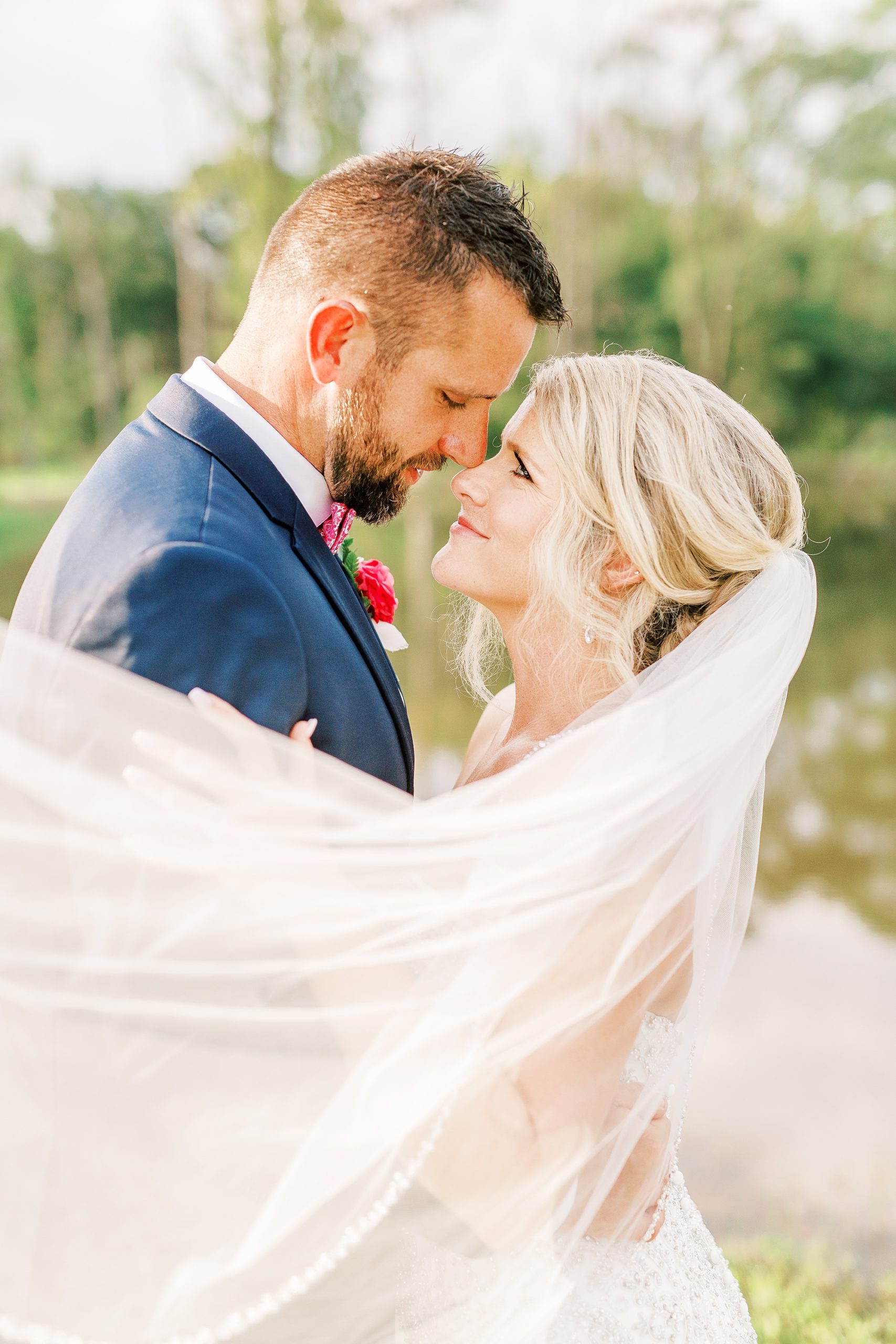 newlyweds pose with veil wrapped around them