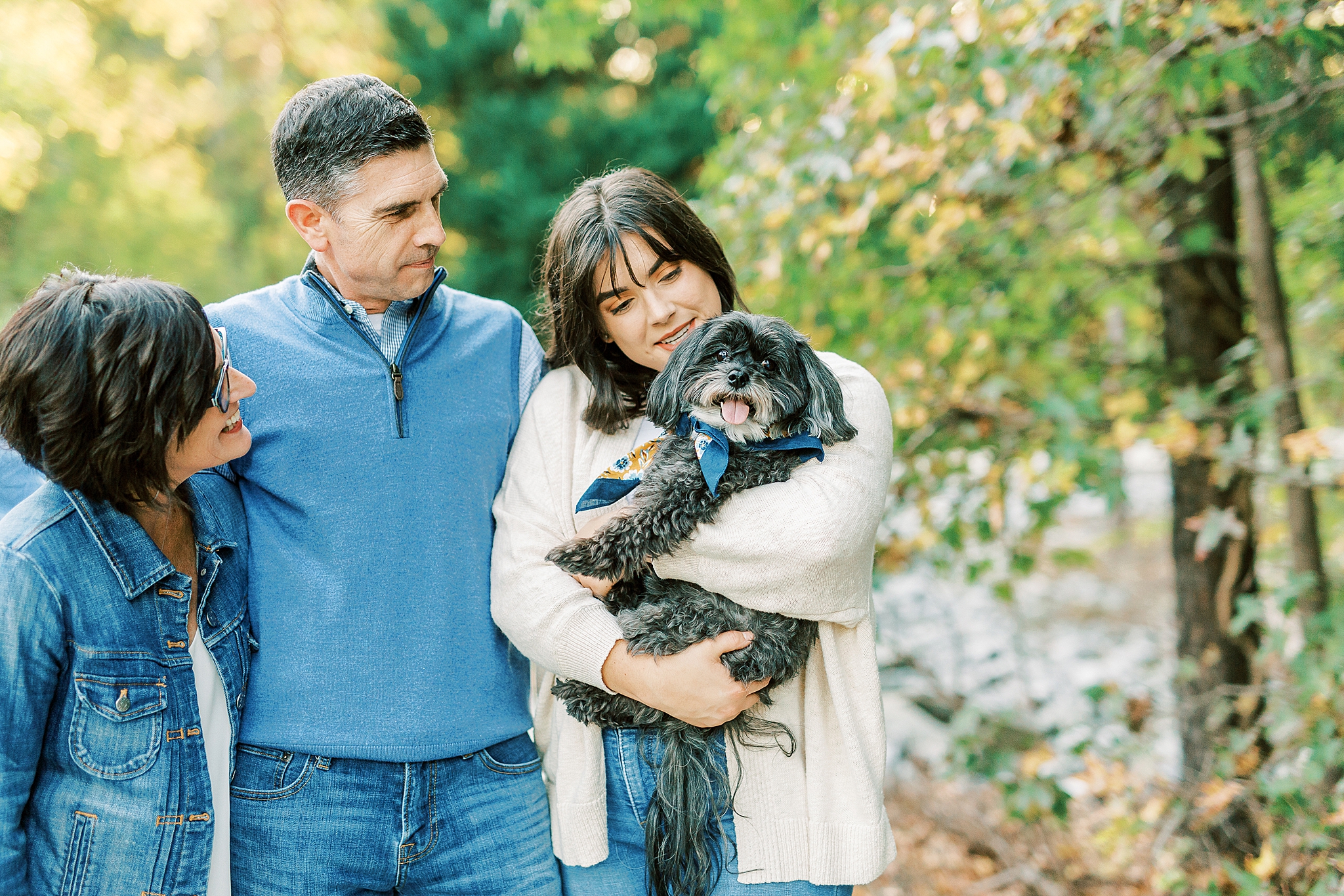 parents look at dog with daughter
