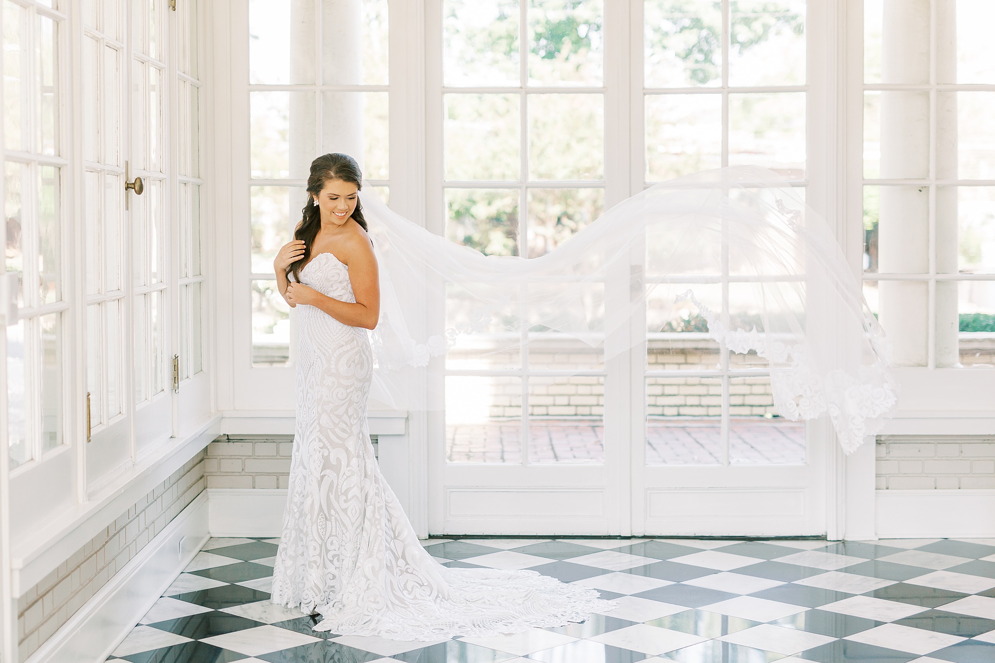 bride poses with veil floating
