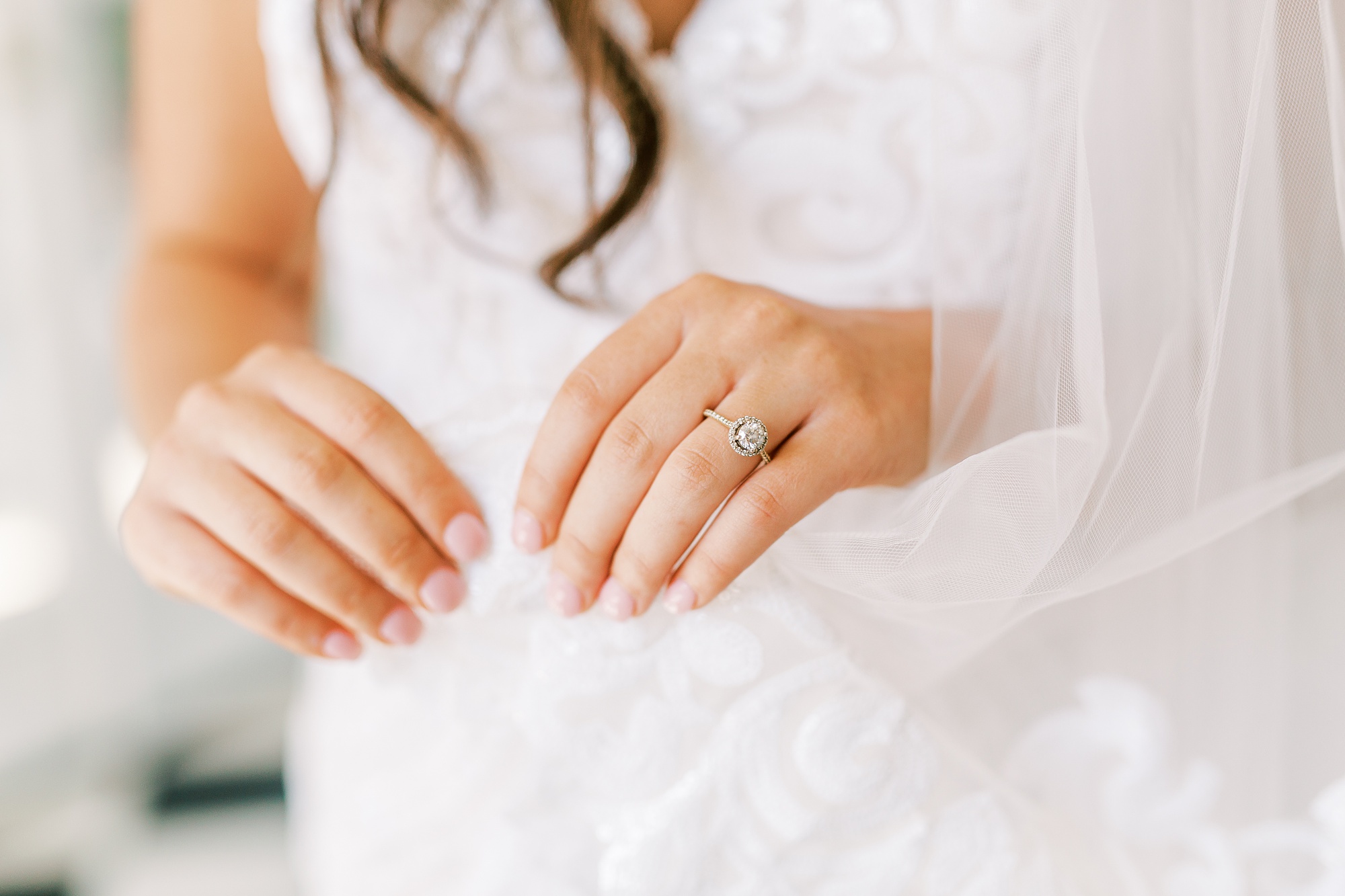 Charlotte NC bride holds veil showing off engagement ring