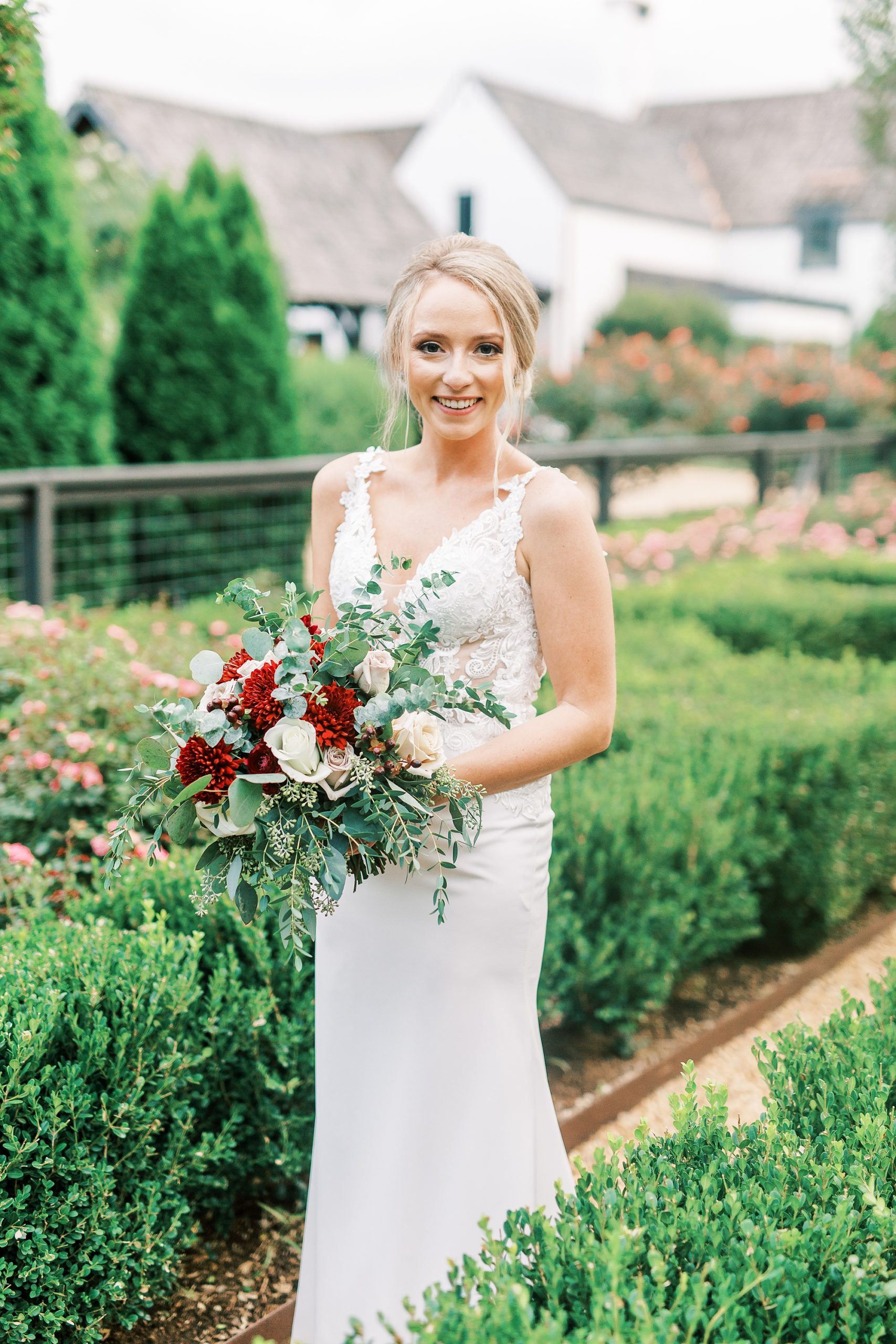 bride holds bouquet of red and white flowers