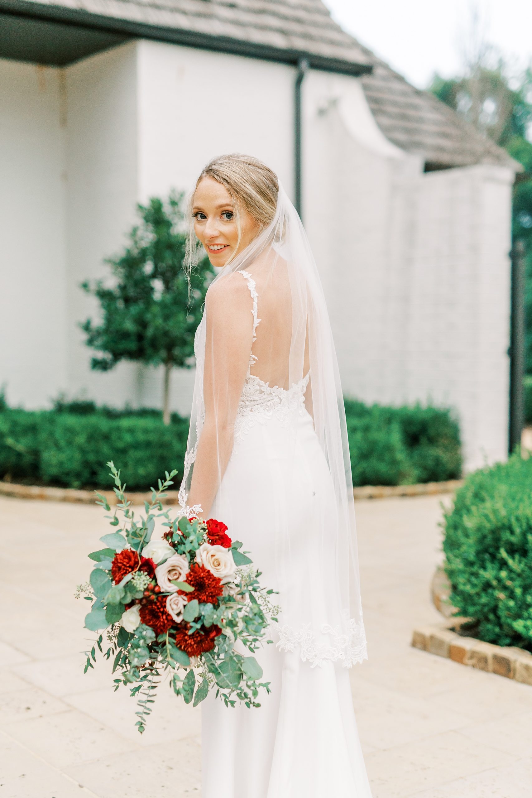 bride looks over her shoulder with veil draped