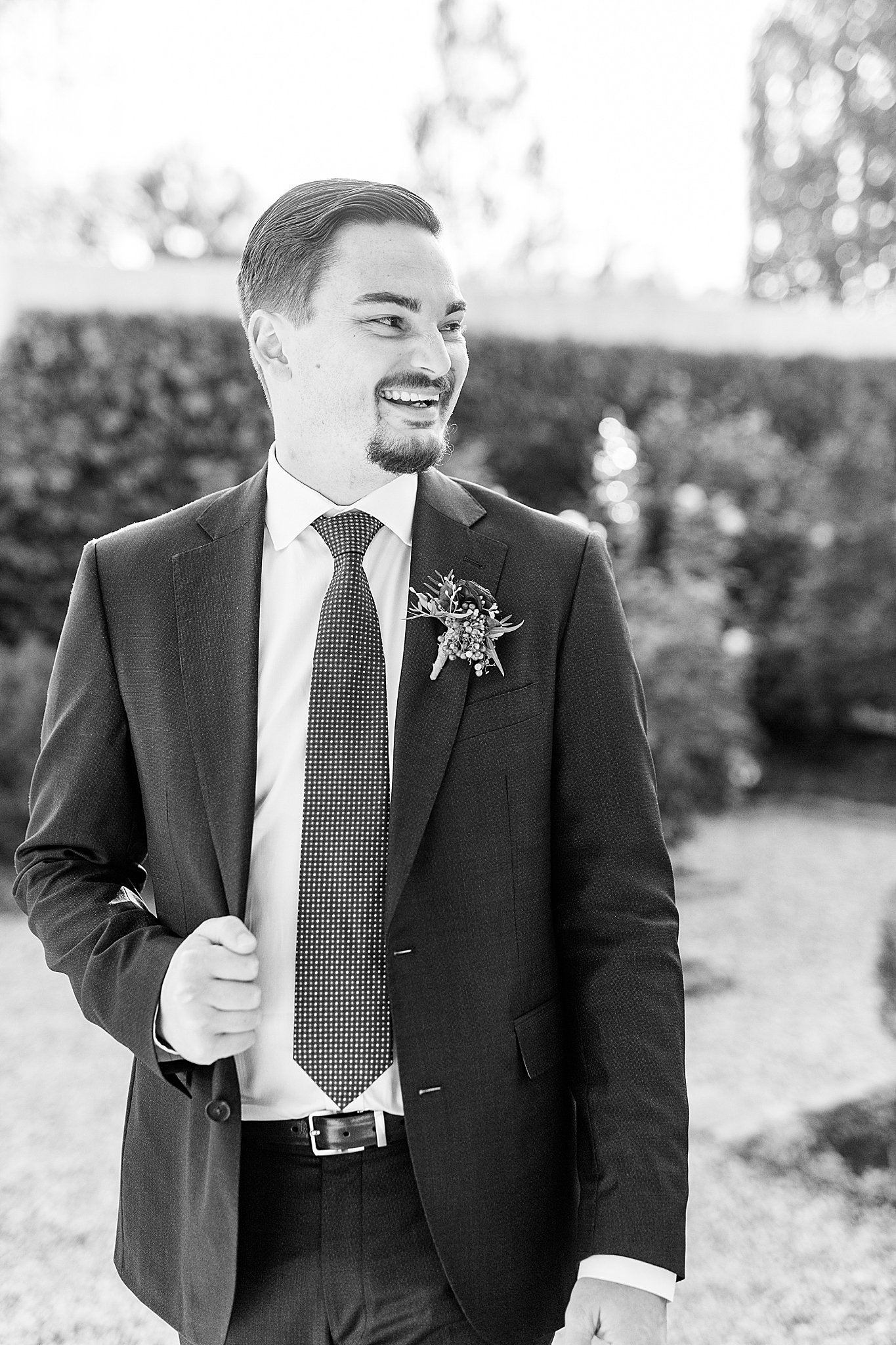groom laughs looking at bride during portraits