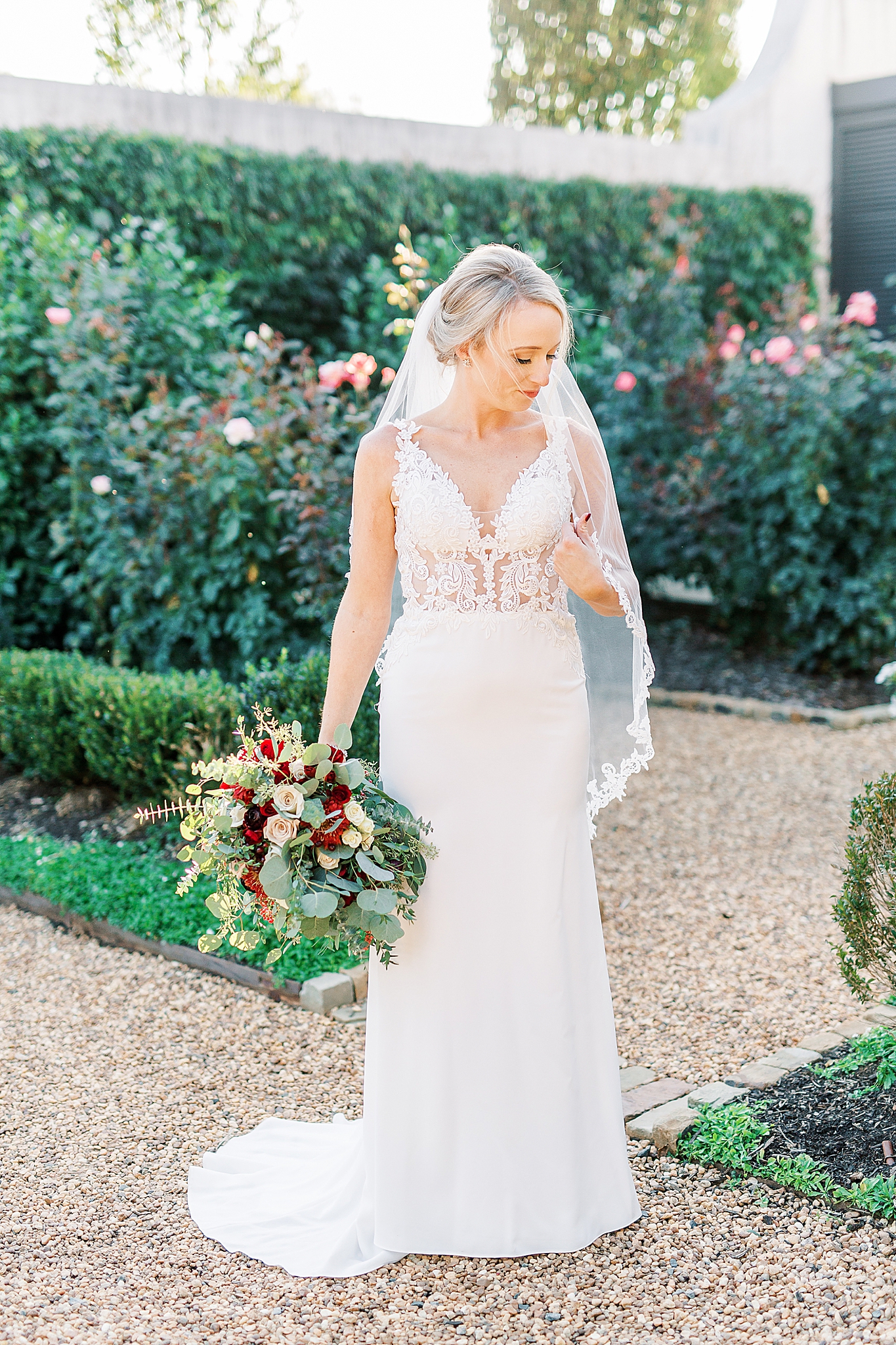 bride holds veil and looks over shoulder during NC wedding day