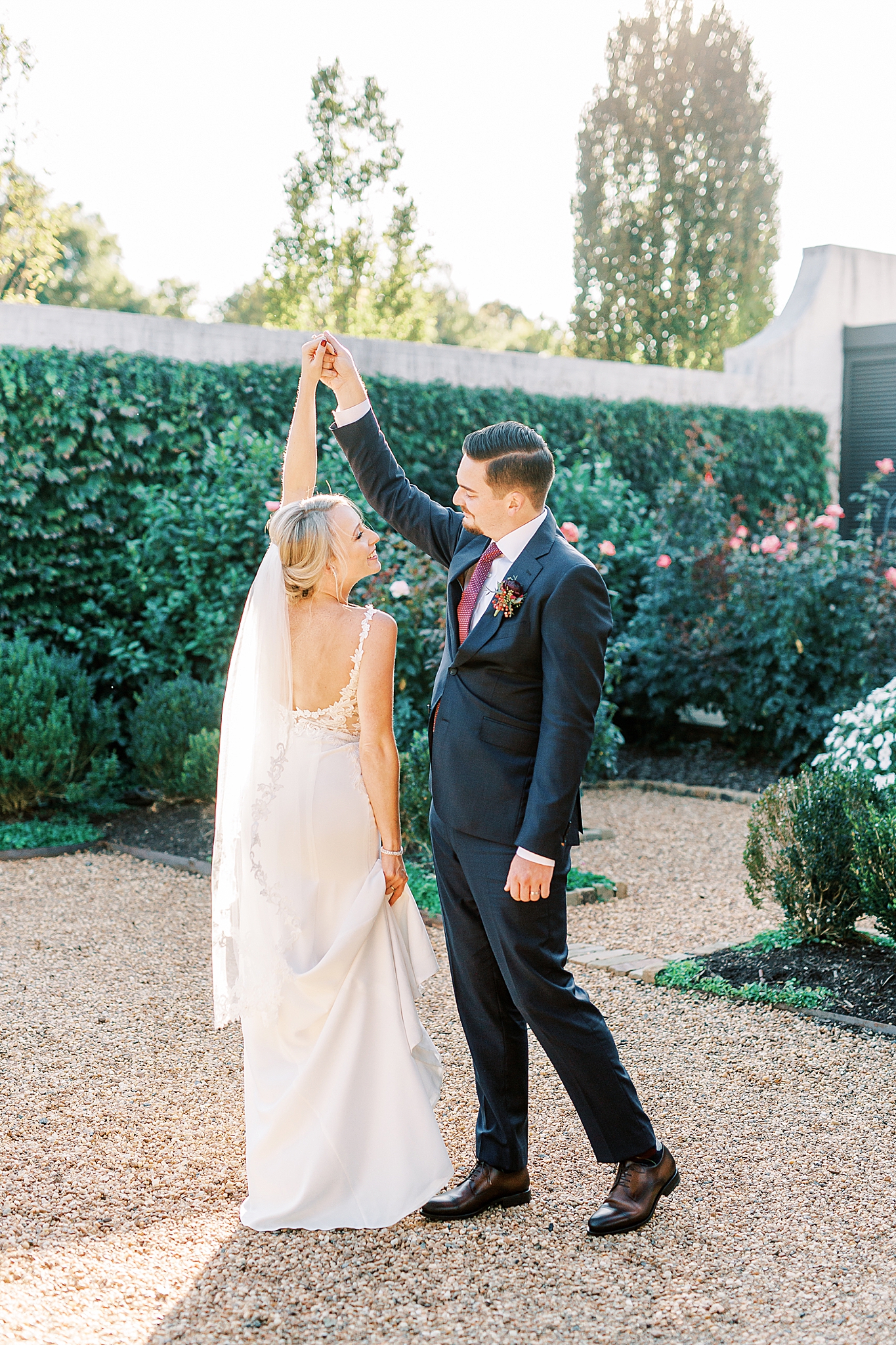 groom twirls bride during NC wedding photos