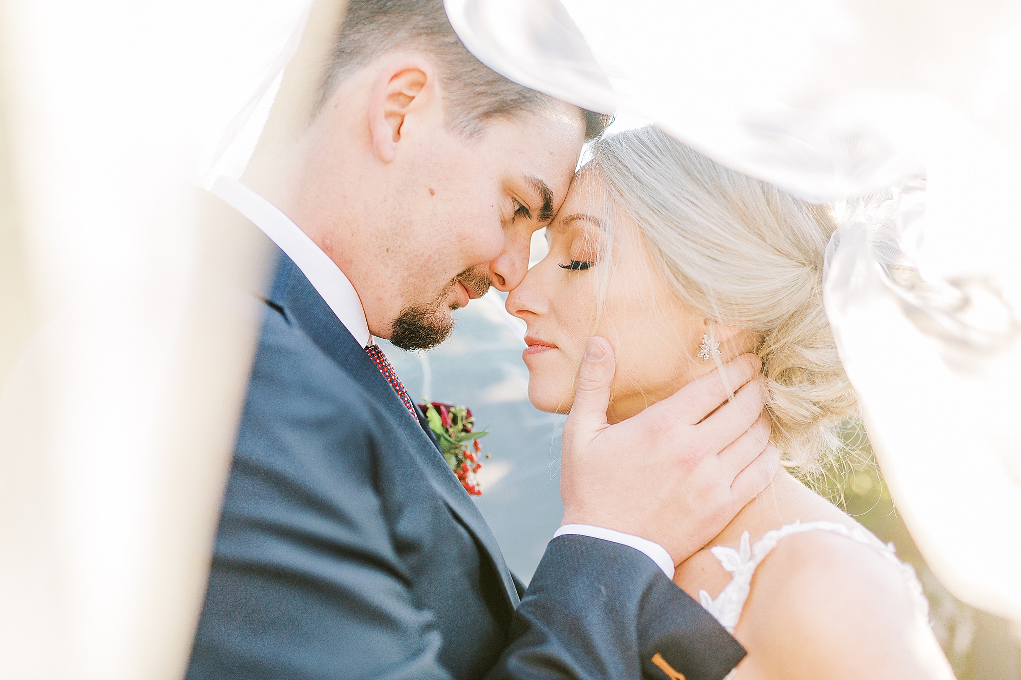 newlyweds pose under bride's veil