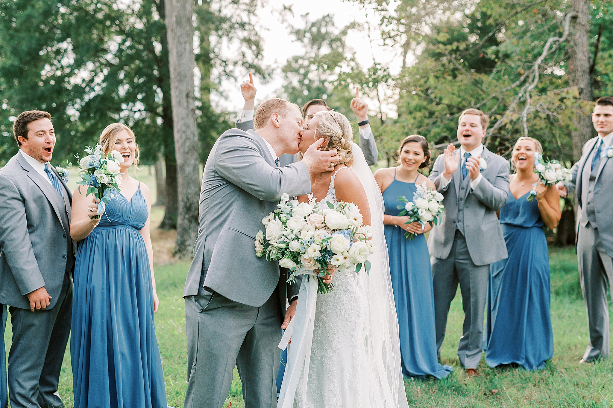 newlyweds kiss while bridal party cheers