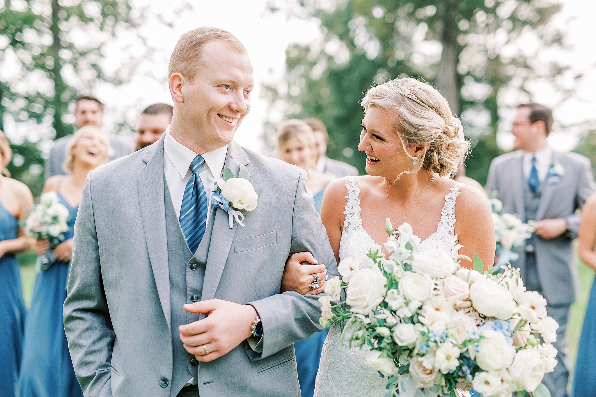 bride and groom laugh at The Farm at Brusharbor with bridal party behind them